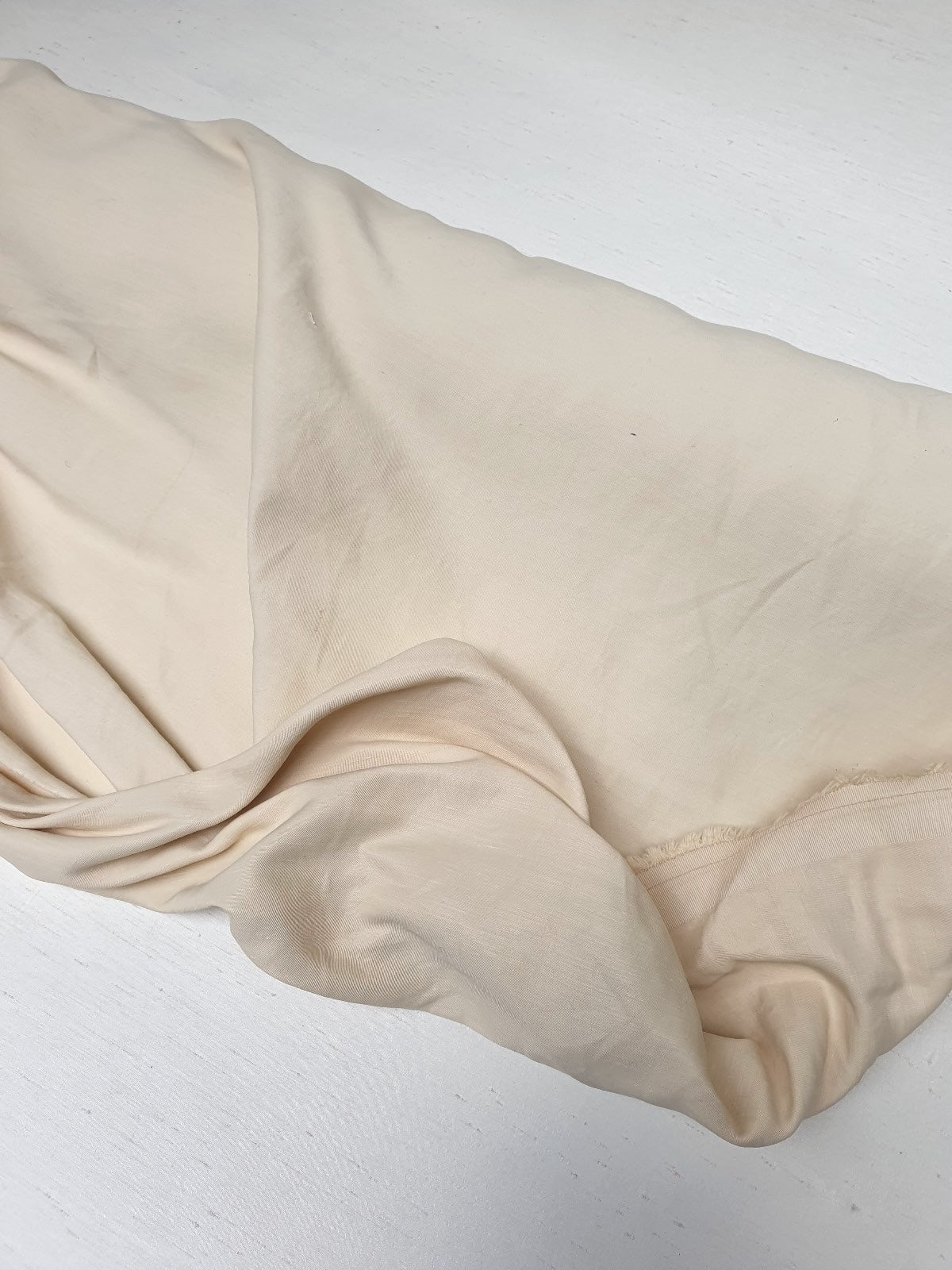 Close-up of a yellow-cream medium-weight taffeta fabric with a soft textured 