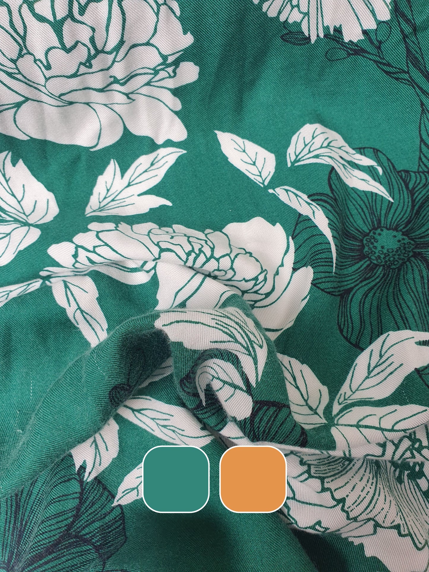A green twill rolled fabric with a floral print with colour swatches below 