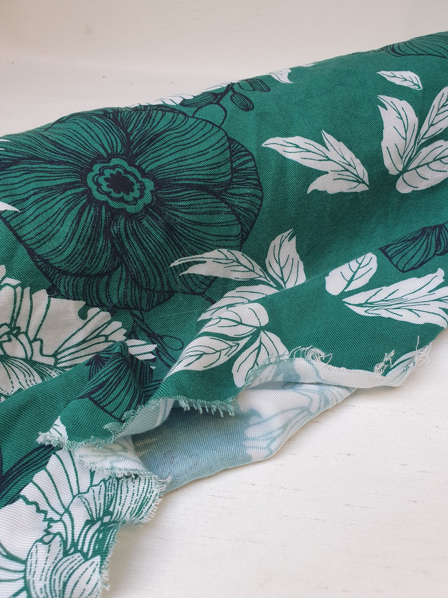 A green twill rolled fabric with a floral print 