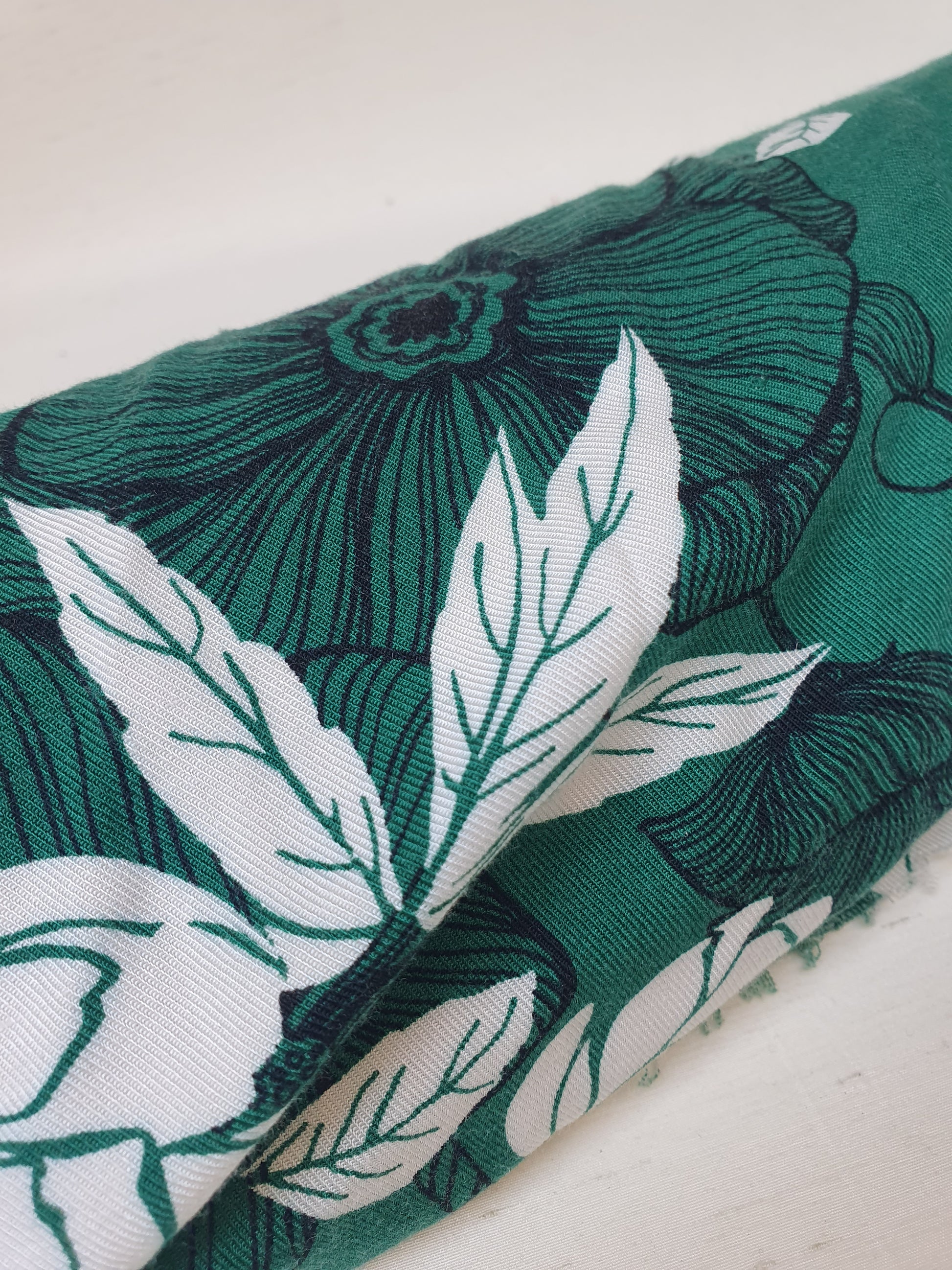 A green twill rolled fabric with a floral print 