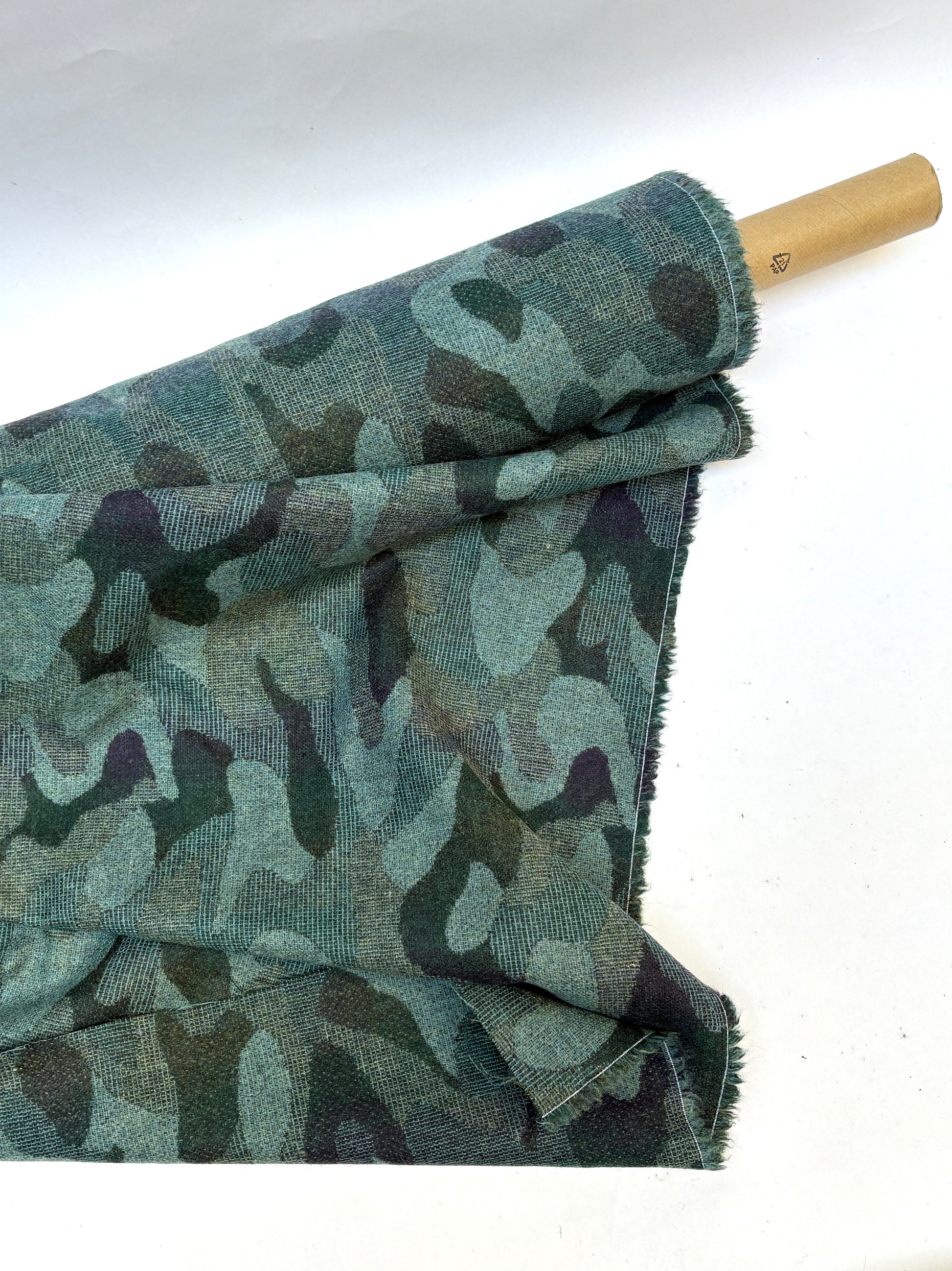 Rolled camouflage-pattern jacquard-weave fabric in green and black.