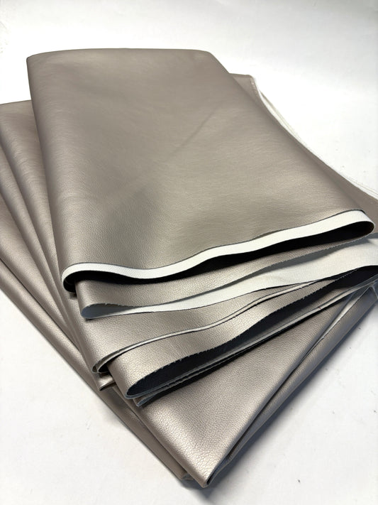 Stack of faux leather in metallic bronze with white backside 