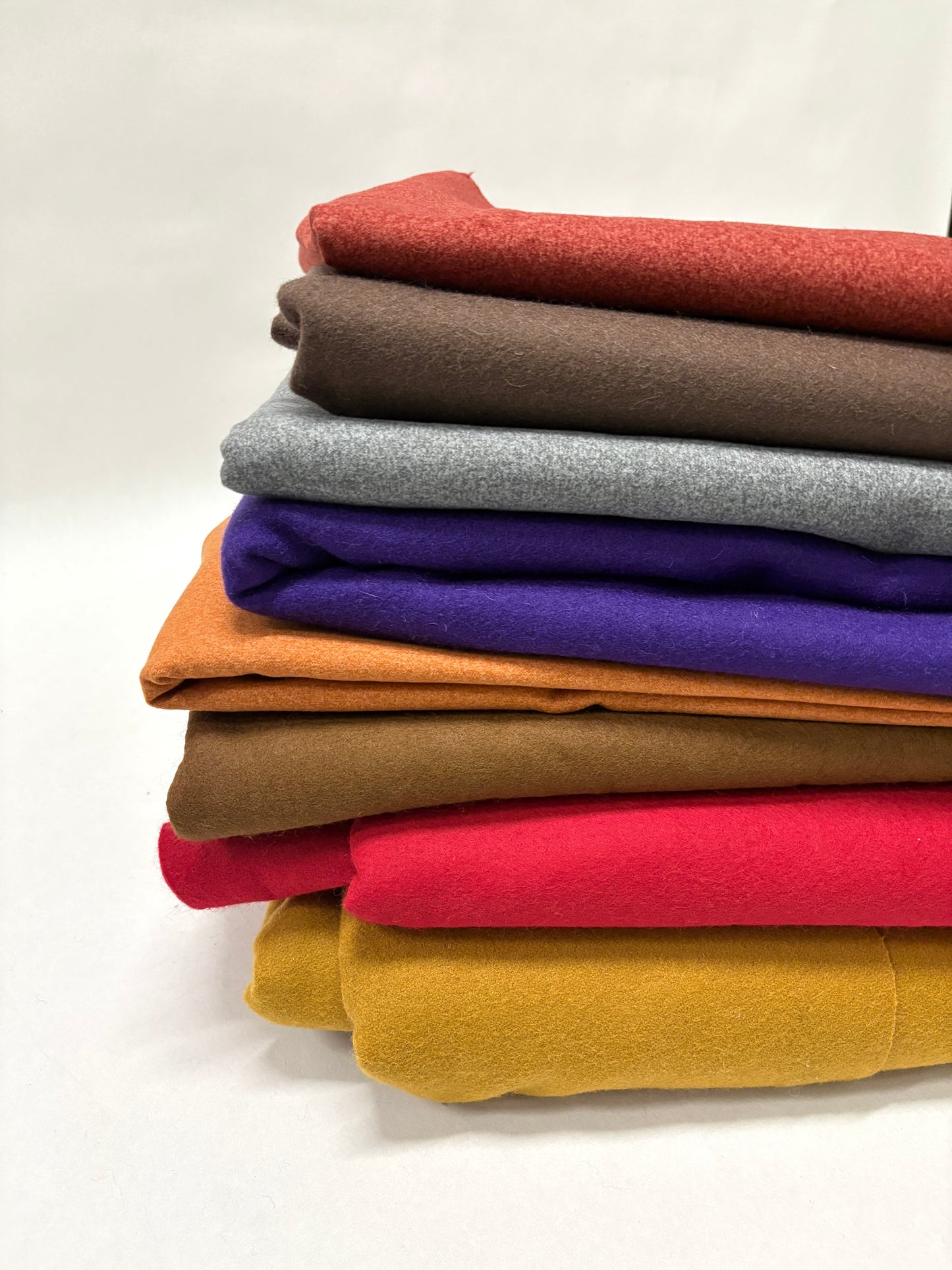Stack of folded felt fabric in various colours 
