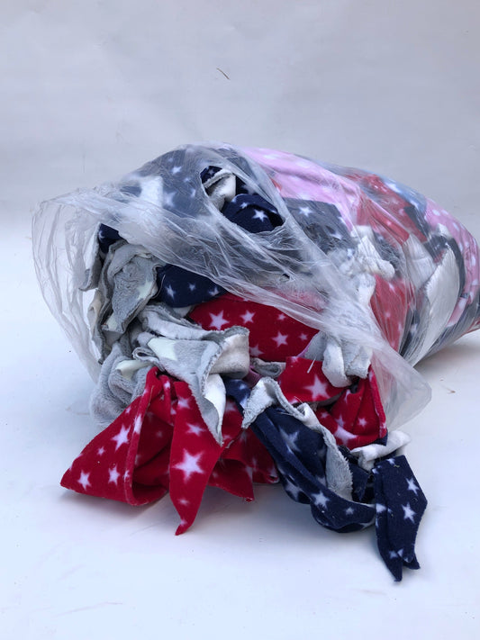 A bag of colourful fleece fabric offcuts with various patterns 