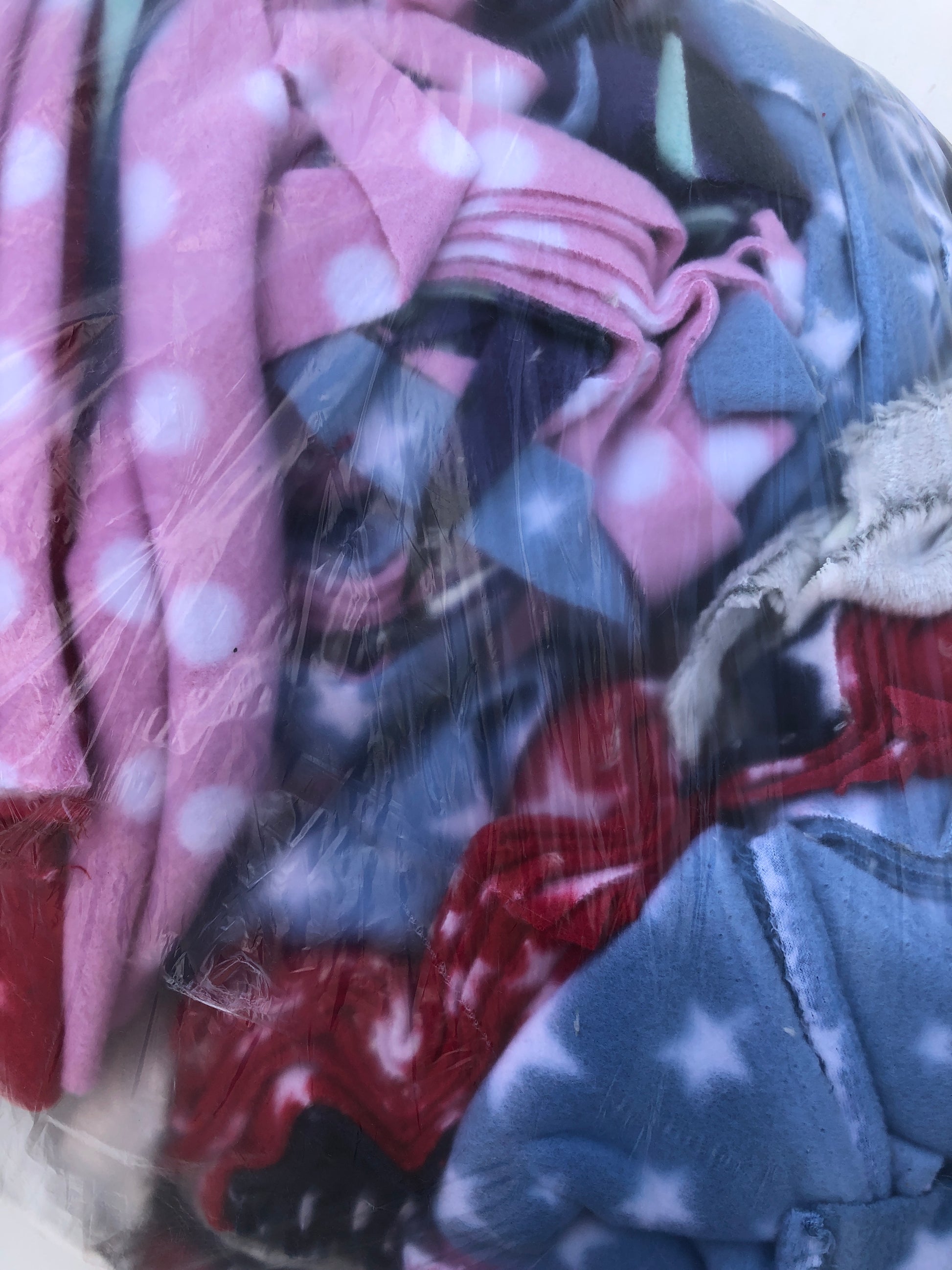 A bag of colourful fleece fabric offcuts with various patterns 