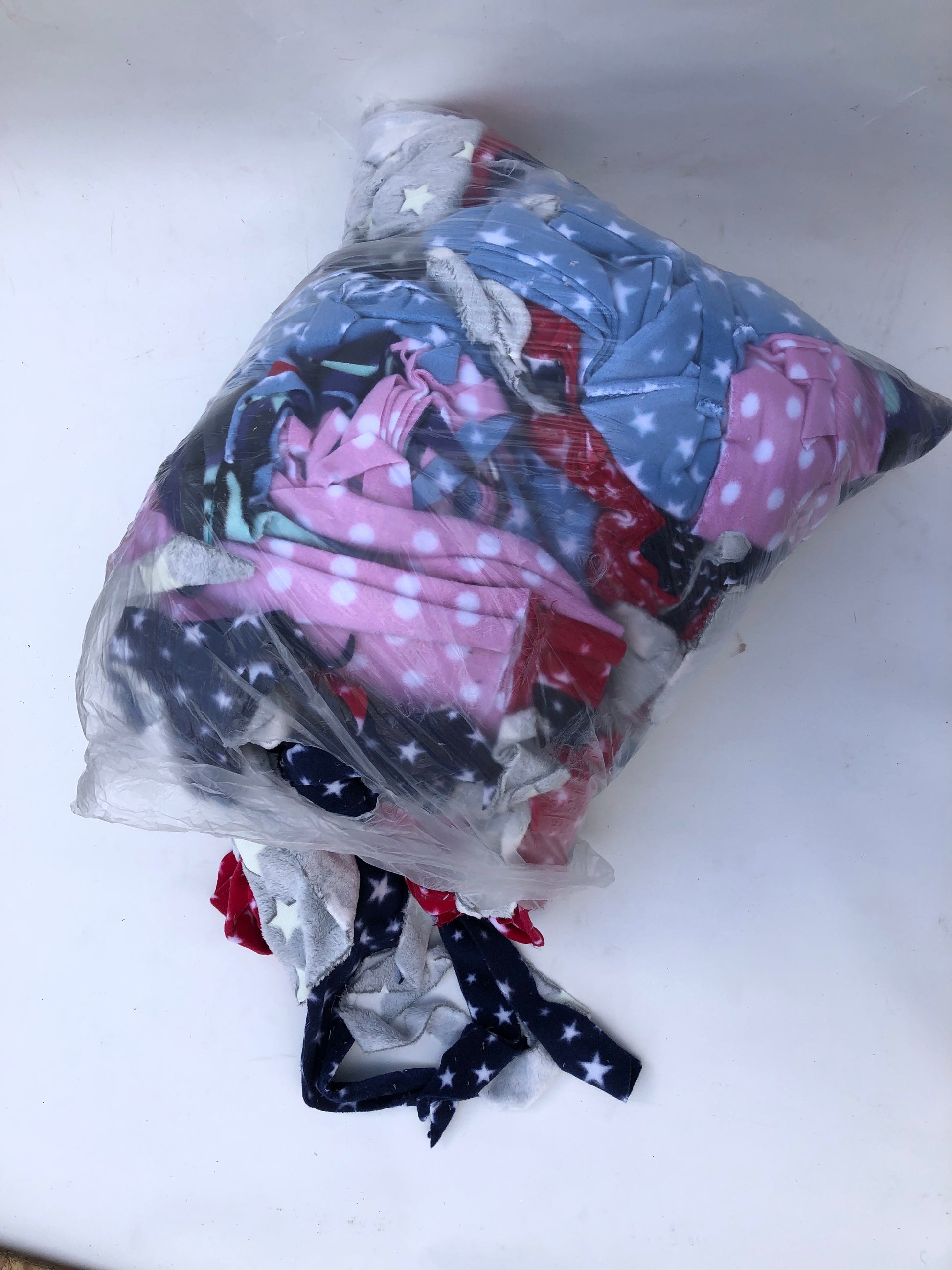 A bag of colourful fleece fabric offcuts with various patterns 