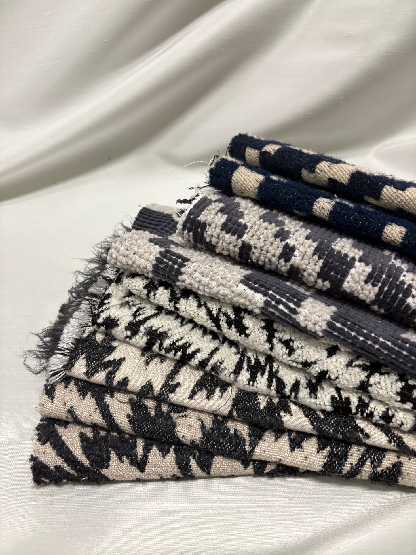 Close-up of a collection of fluffy heavyweight fabric with various patterns in white, blue, and black 