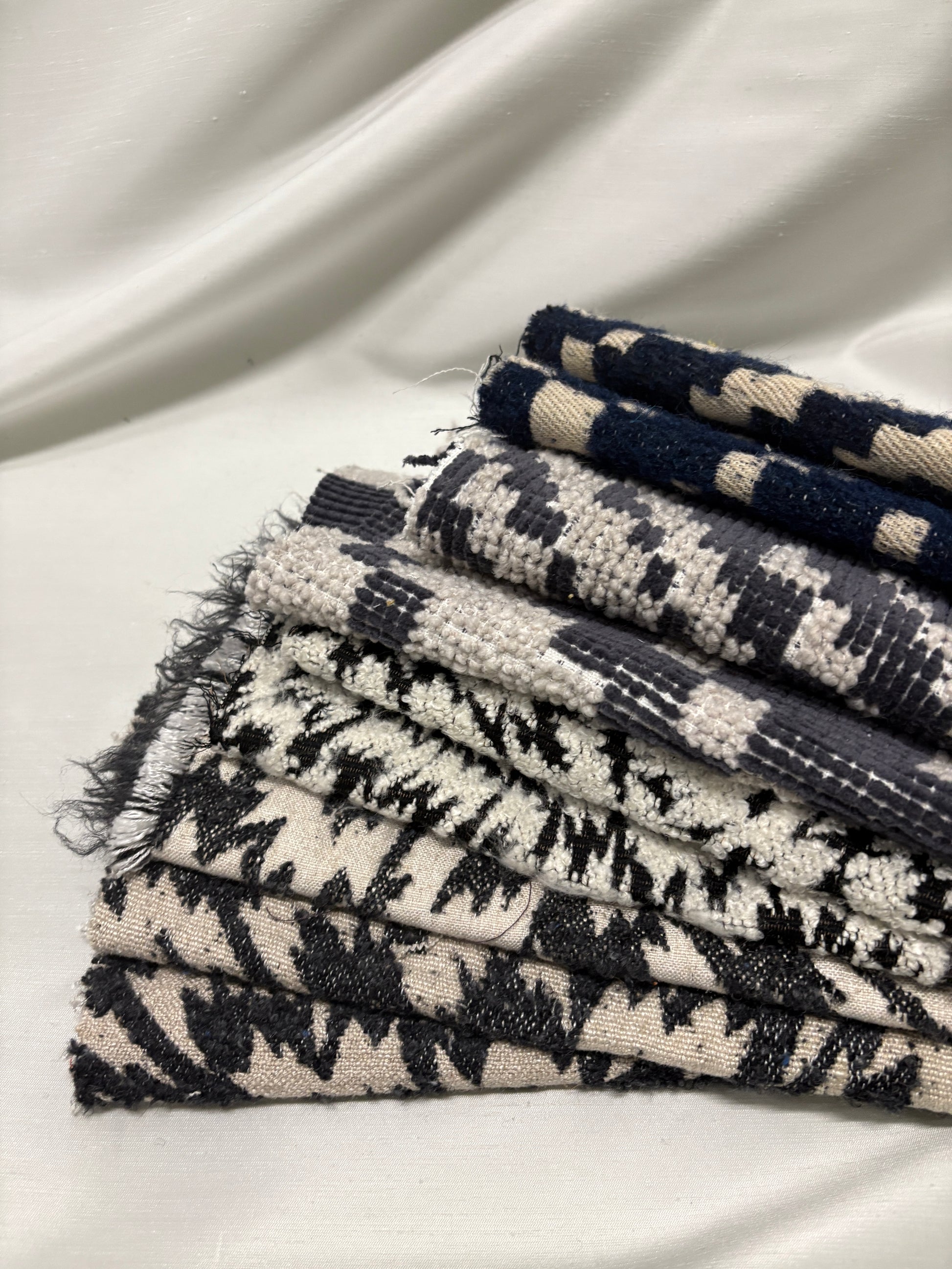 Close-up of a collection of fluffy heavyweight fabric with various patterns in white, blue, and black 