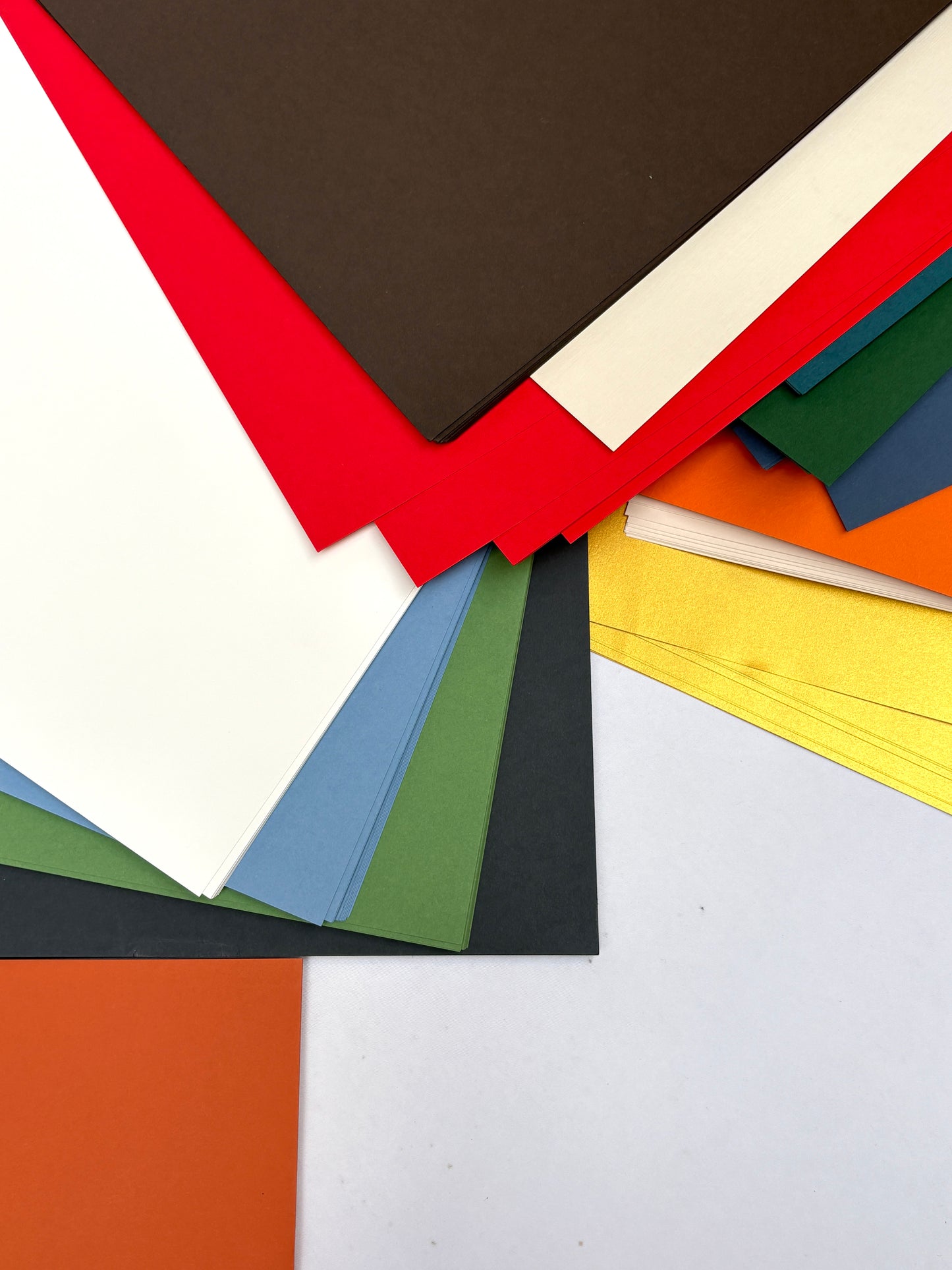 Stack of GF Smith colourful paper 