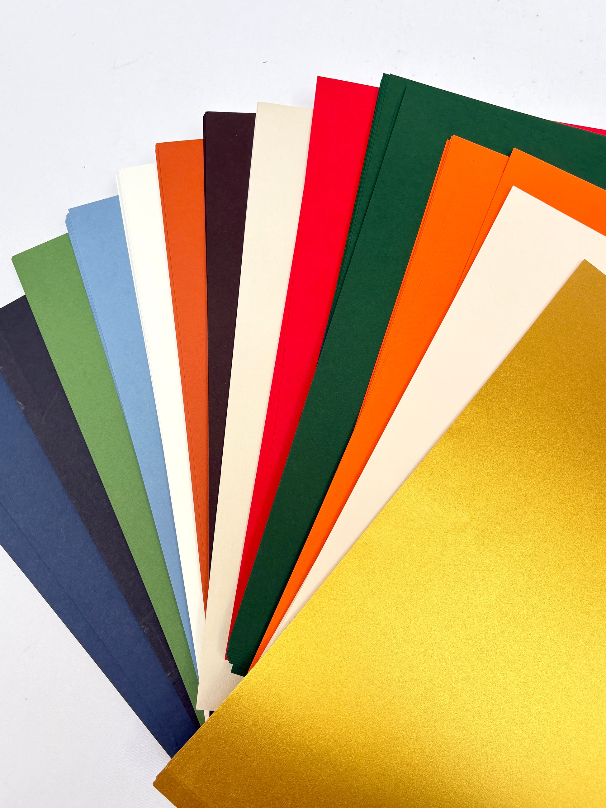 Stack of GF Smith colourful paper 