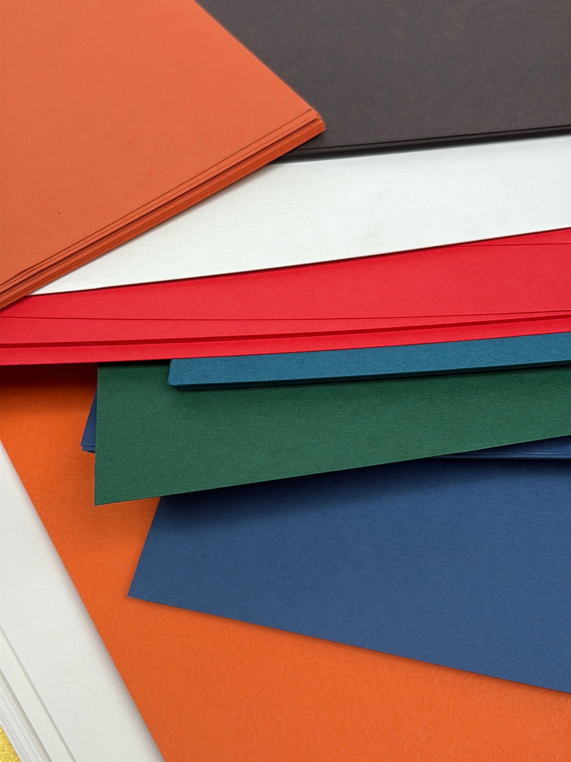 Stack of GF Smith colourful paper 