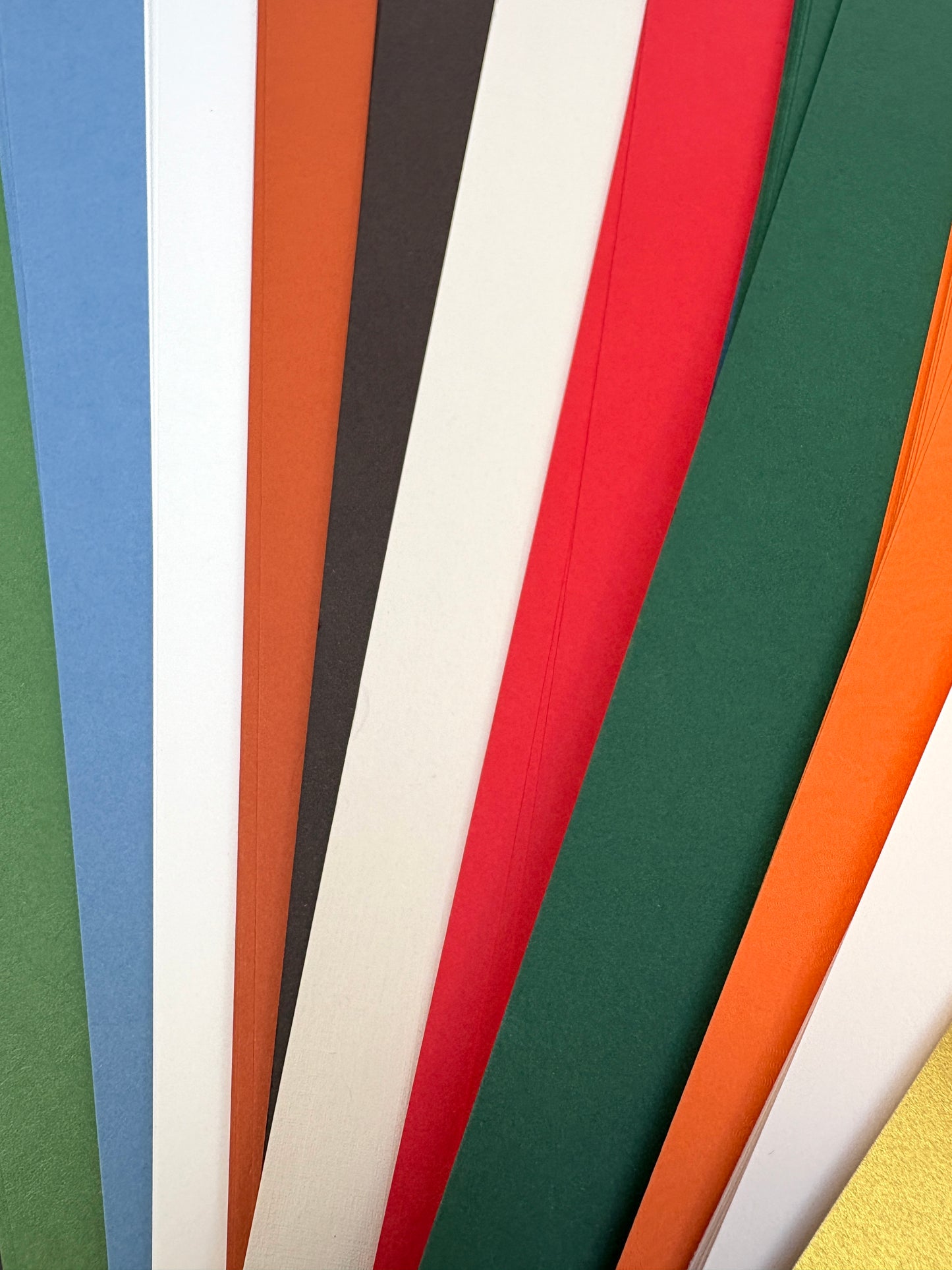 Stack of GF Smith colourful paper 