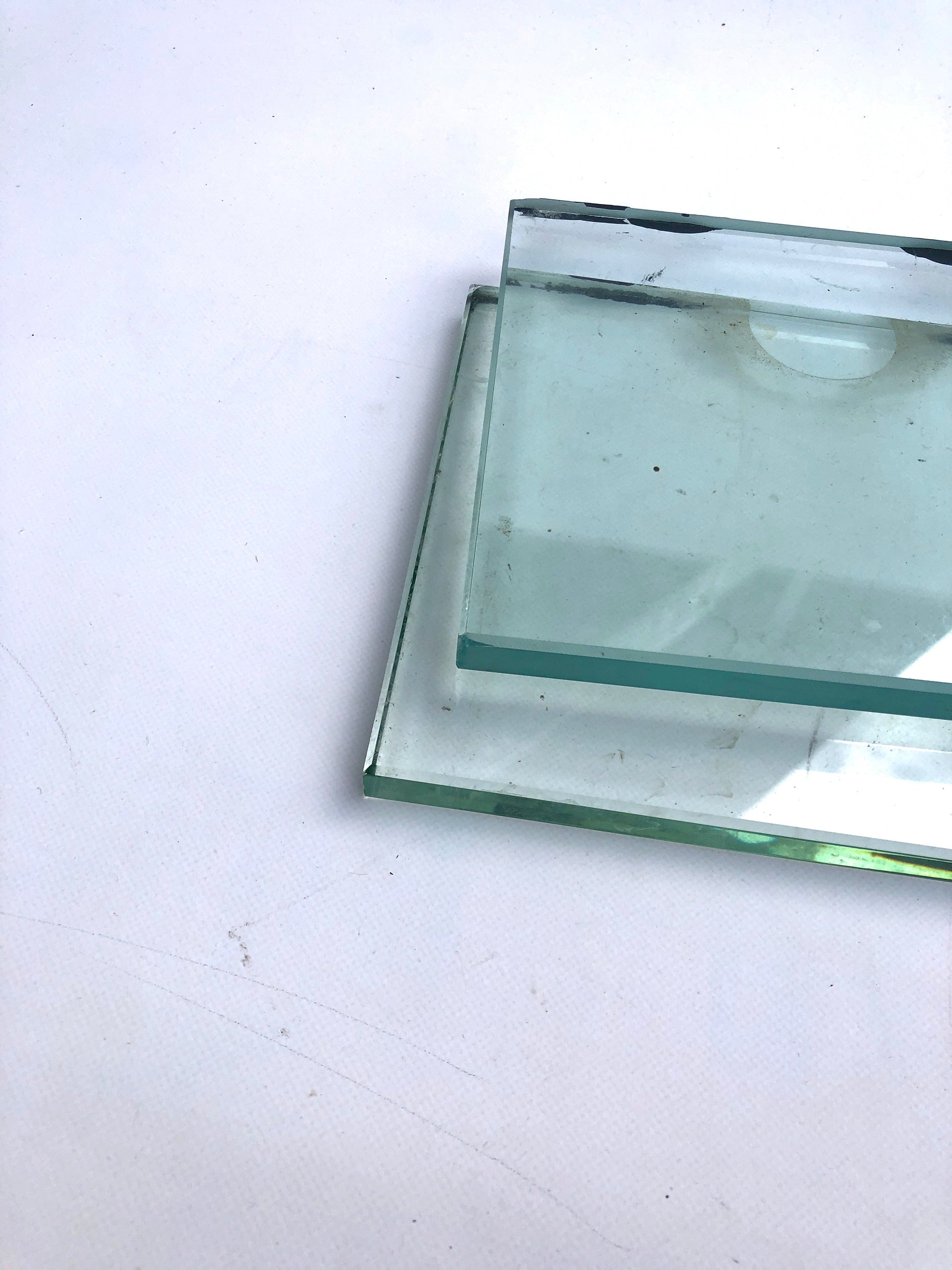     Two rectangular glass pieces are shown overlapped on a white surface