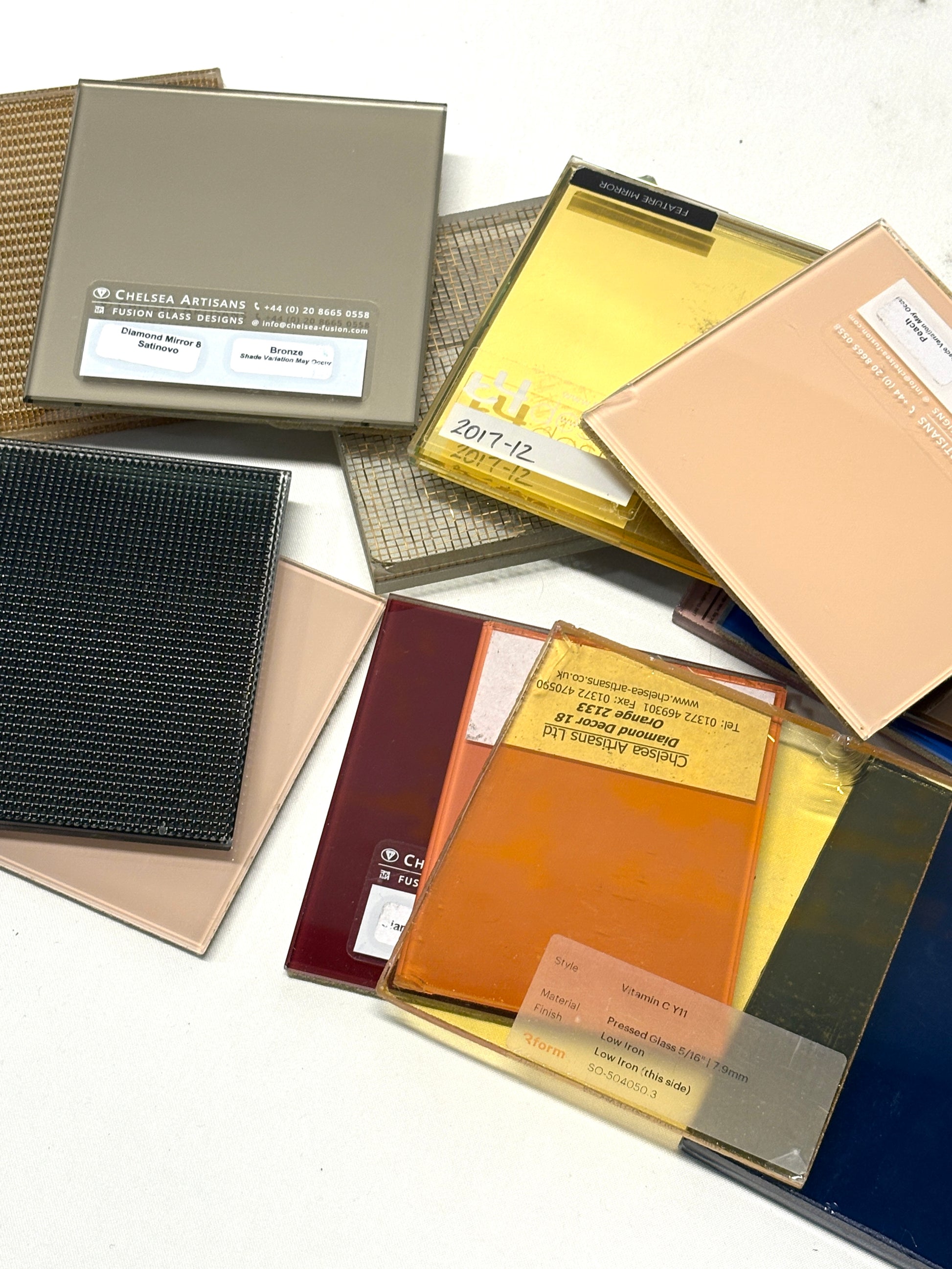 Collection of square colourful glass samples, some pieces are transparent