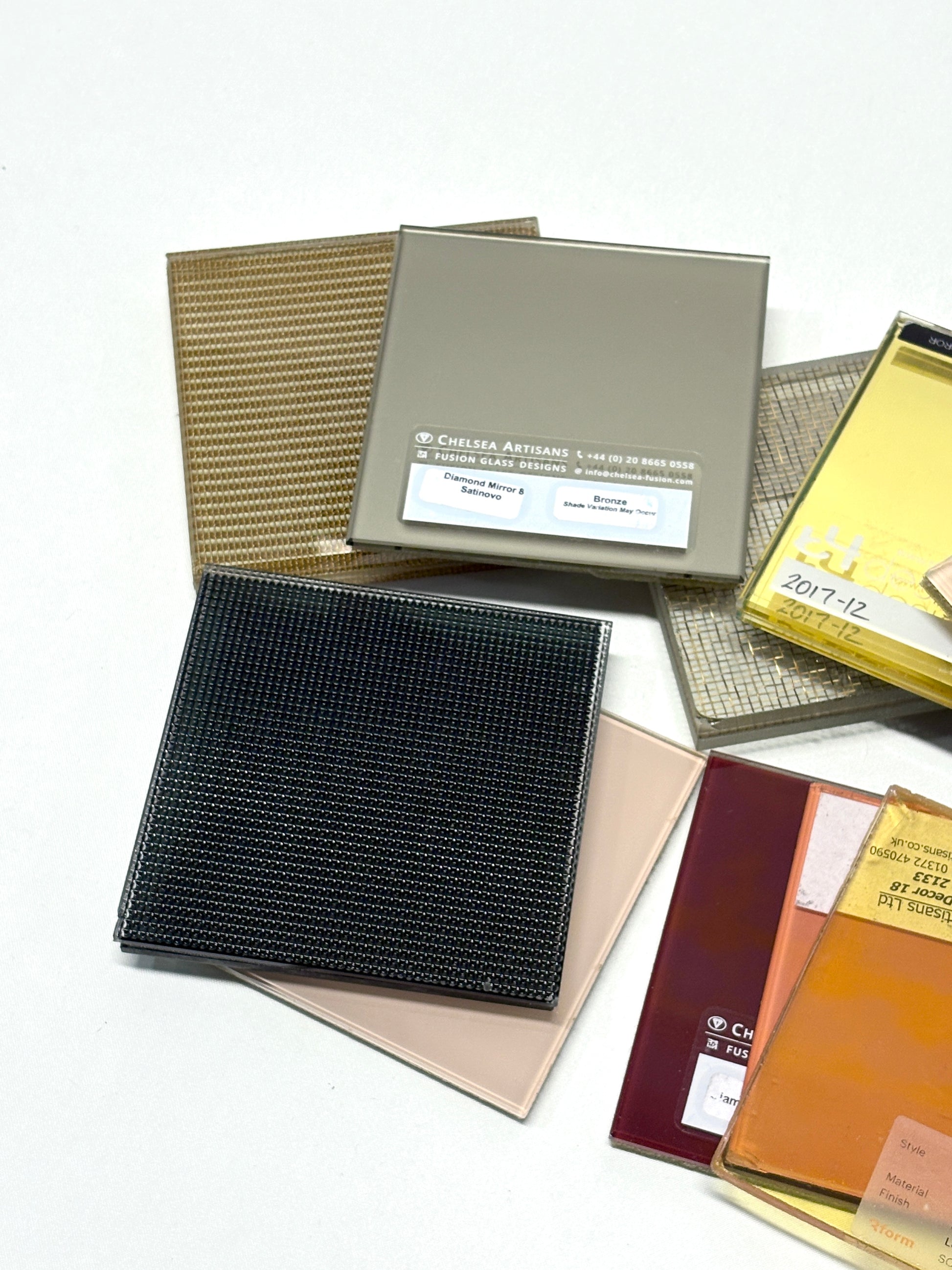 Close-up of a collection of square colourful glass samples with various patterns 