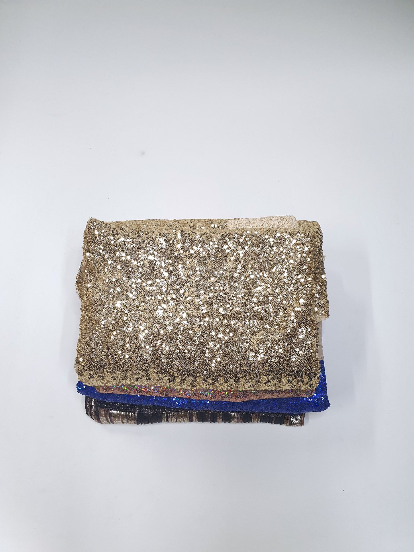 Pile of folded glitter fabric with various colours 