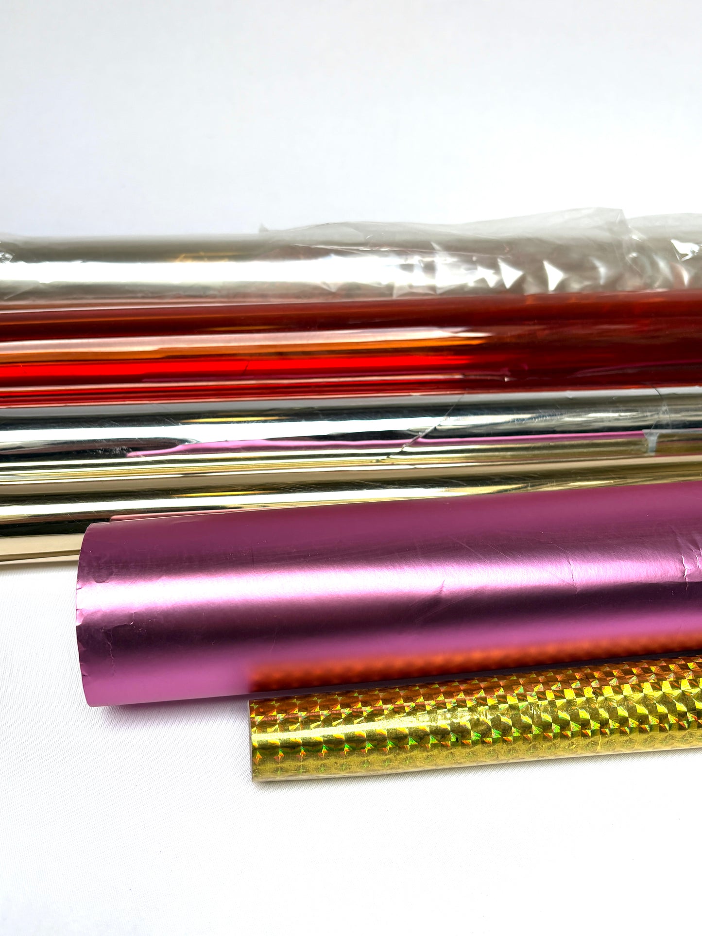 Collection of colourful glossy paper plastic rolls 