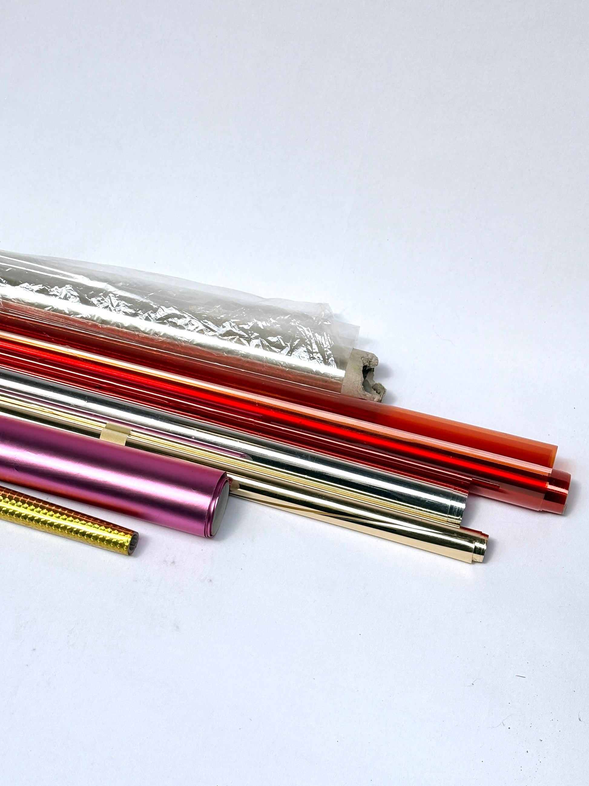Collection of colourful glossy paper plastic rolls 