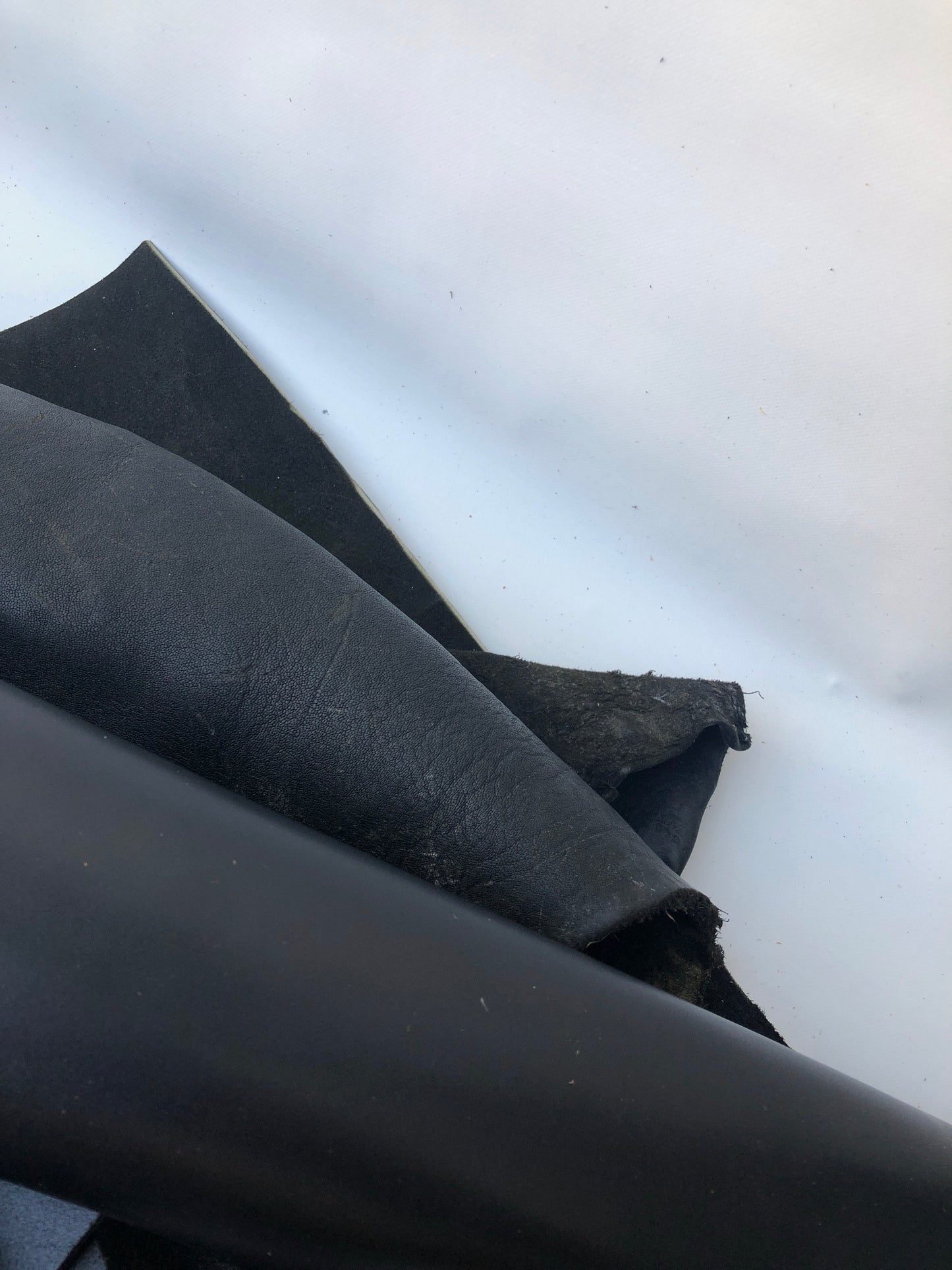 Close-up of black rolled leather with some scars 