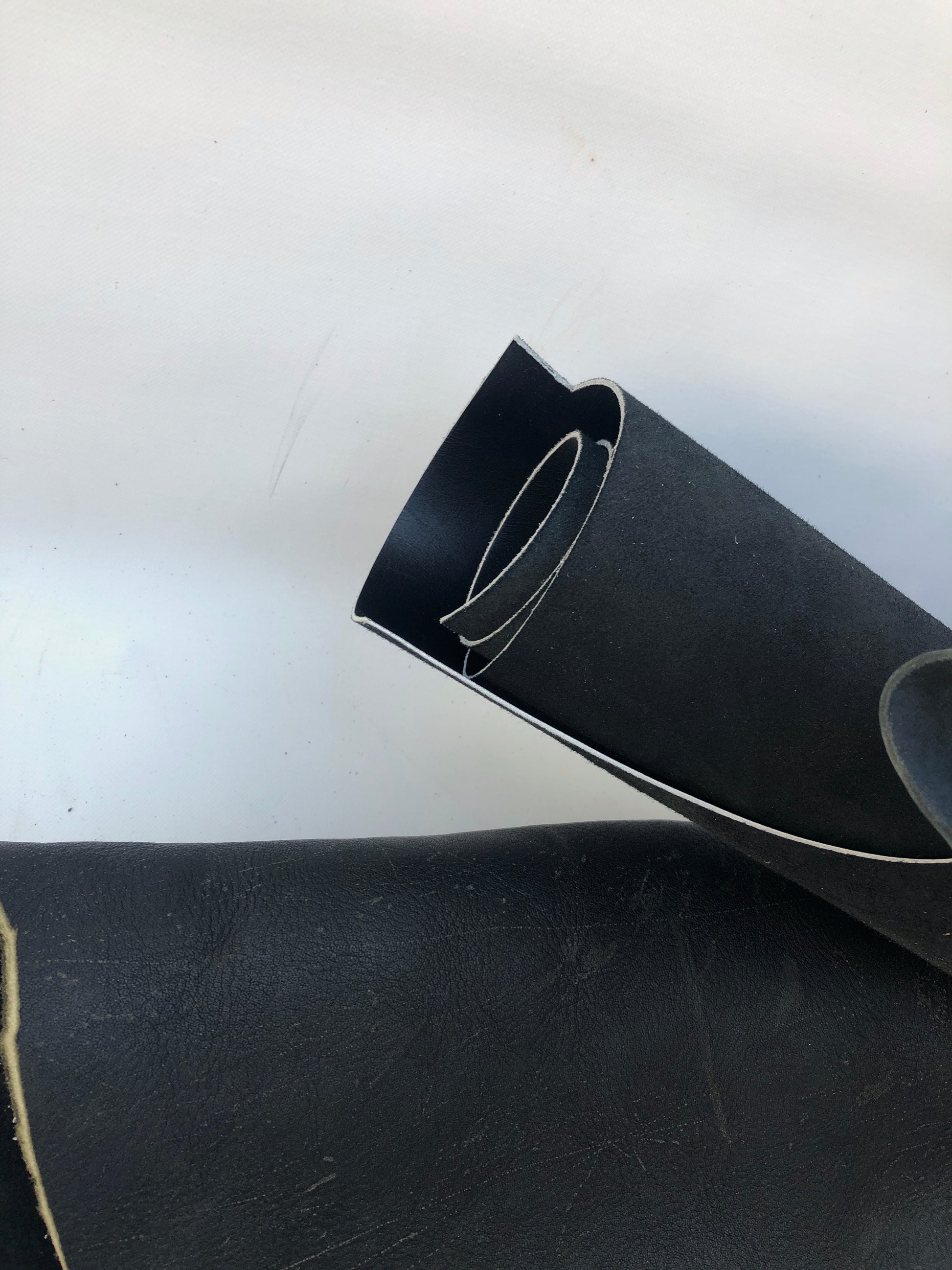 Close-up of black rolled leather with some scars 