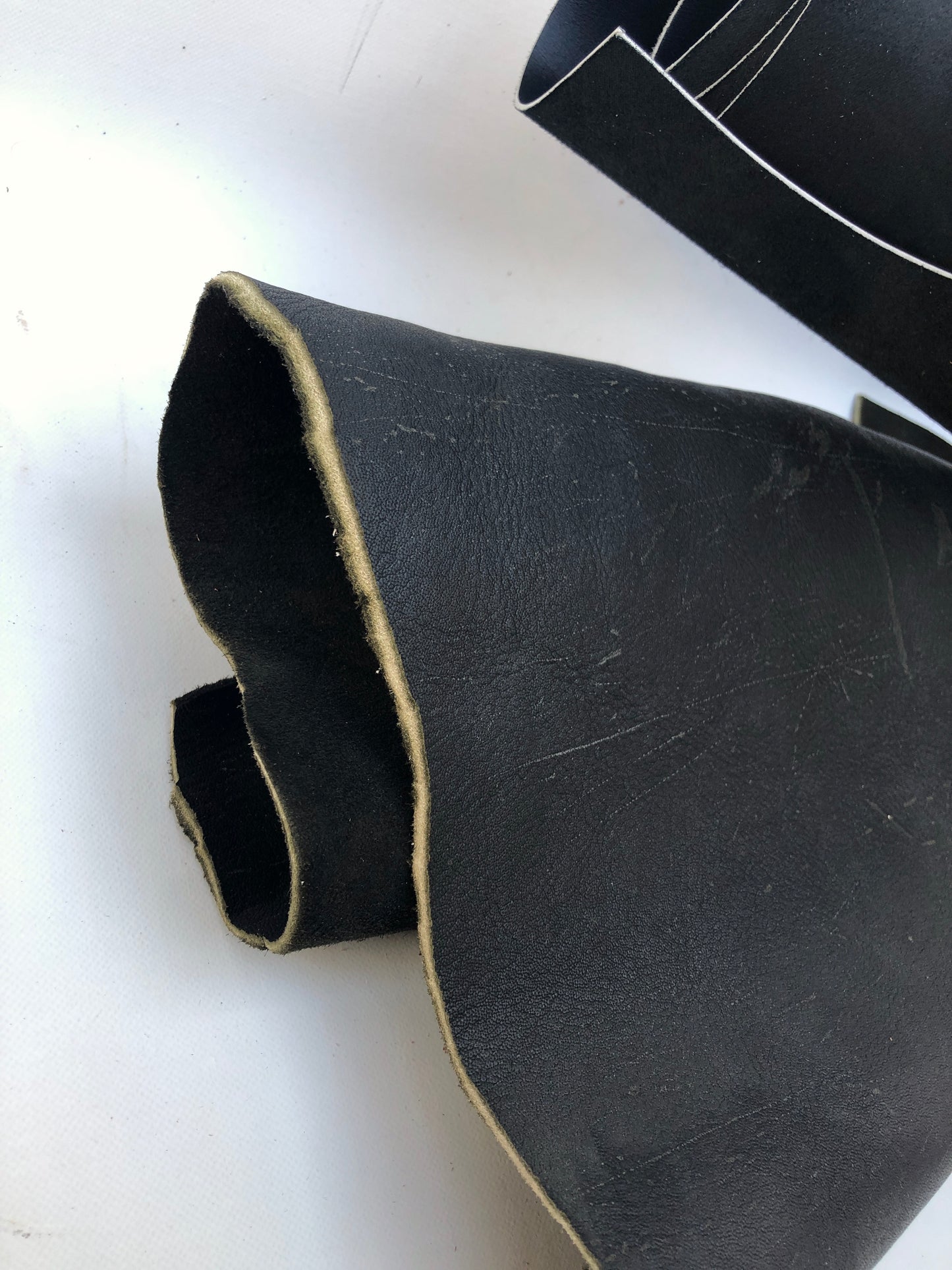 Close-up of black rolled leather with some scars 