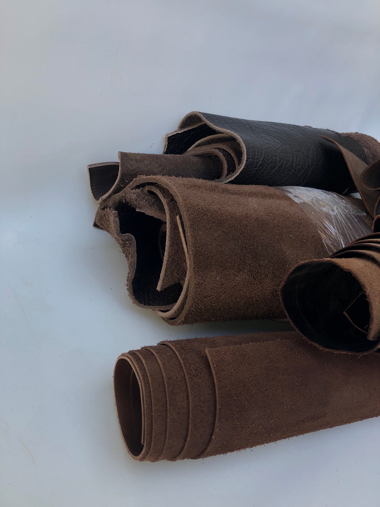Close-up of a collection of dark brown rolled leather