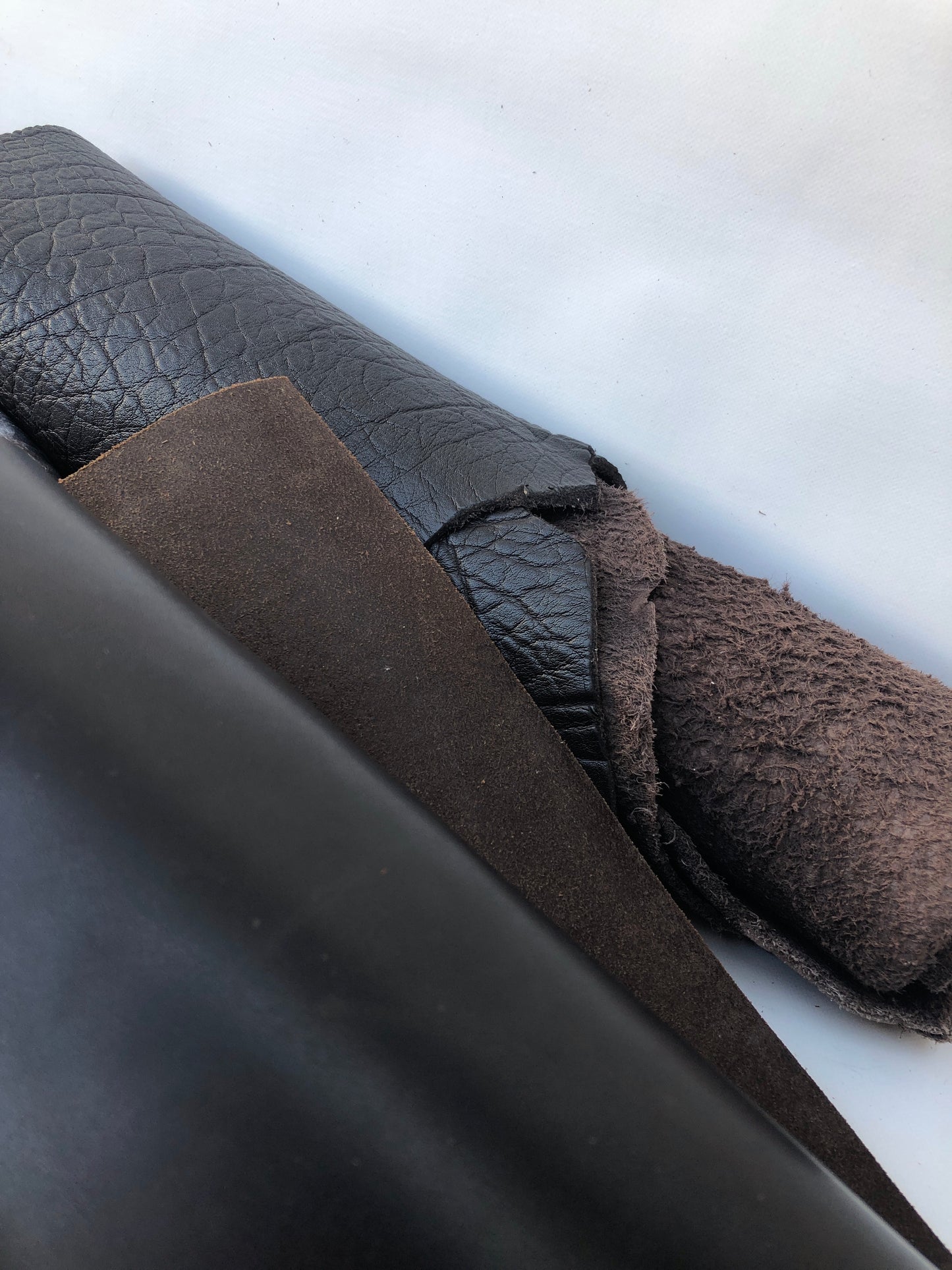 Close-up of a collection of dark brown rolled leather