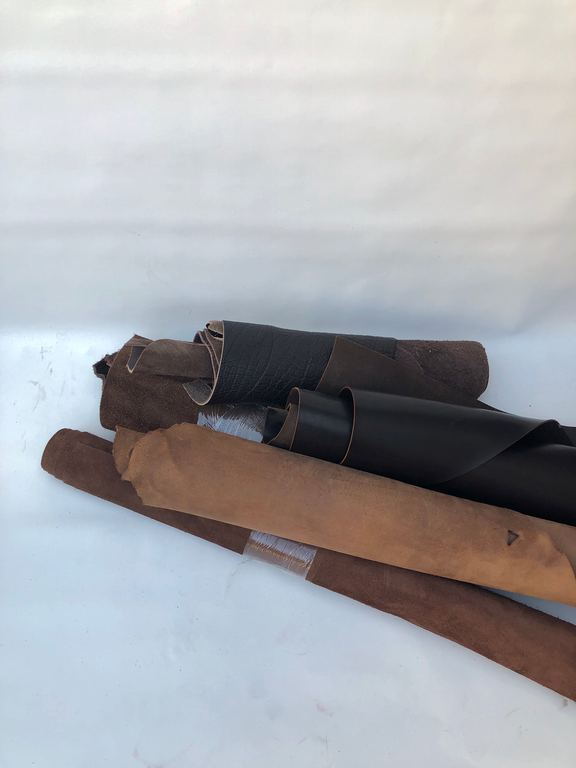 Collection of dark brown rolled leather, some part had cut