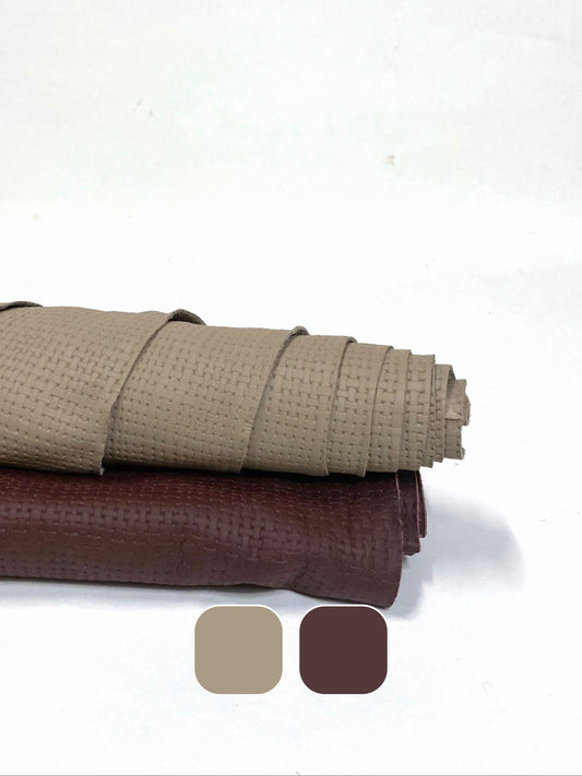 Two rolled-up embossed leather, one beige and one brown with colour swatches