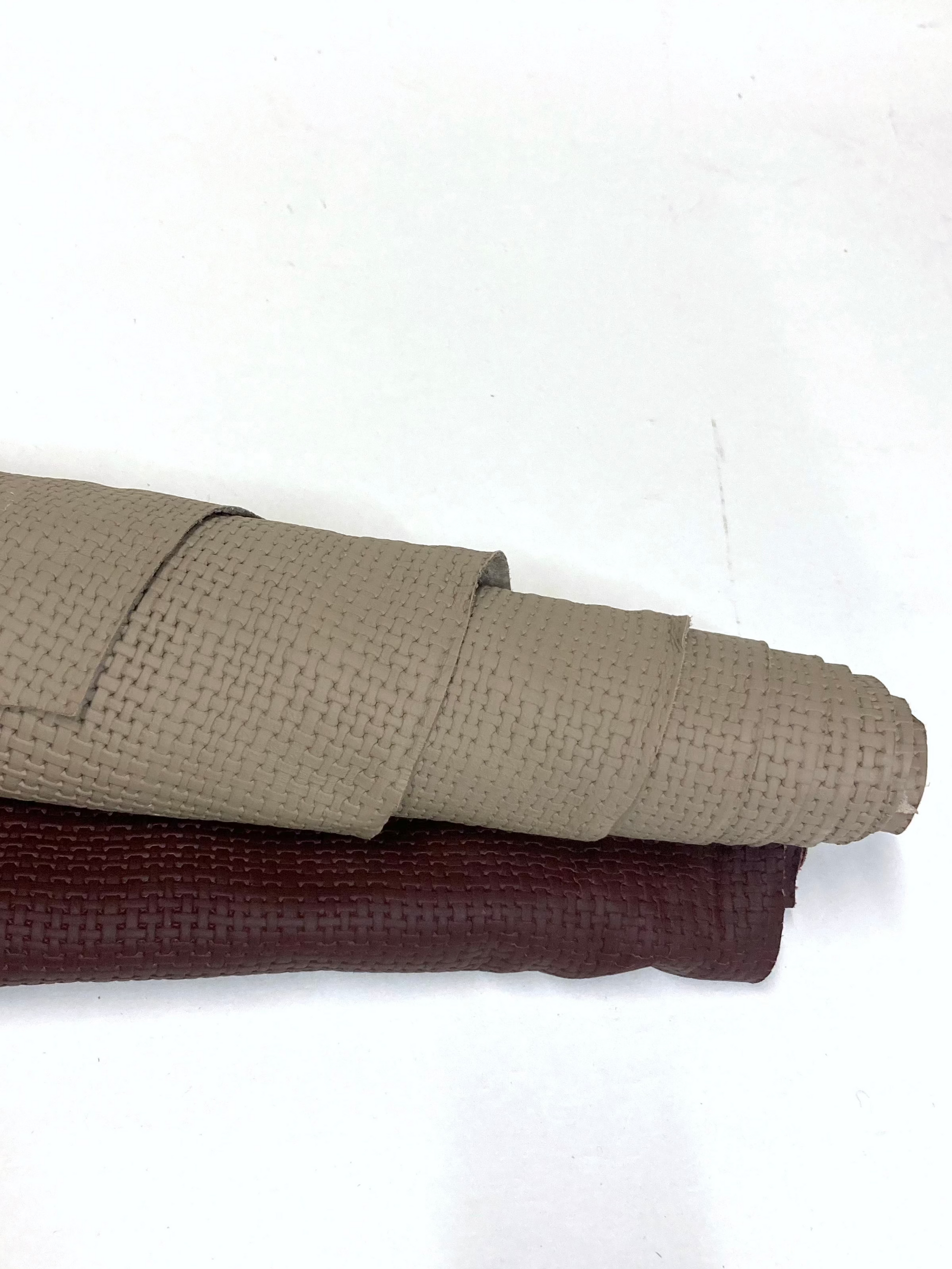 Two rolled-up embossed leather, one beige and one brown