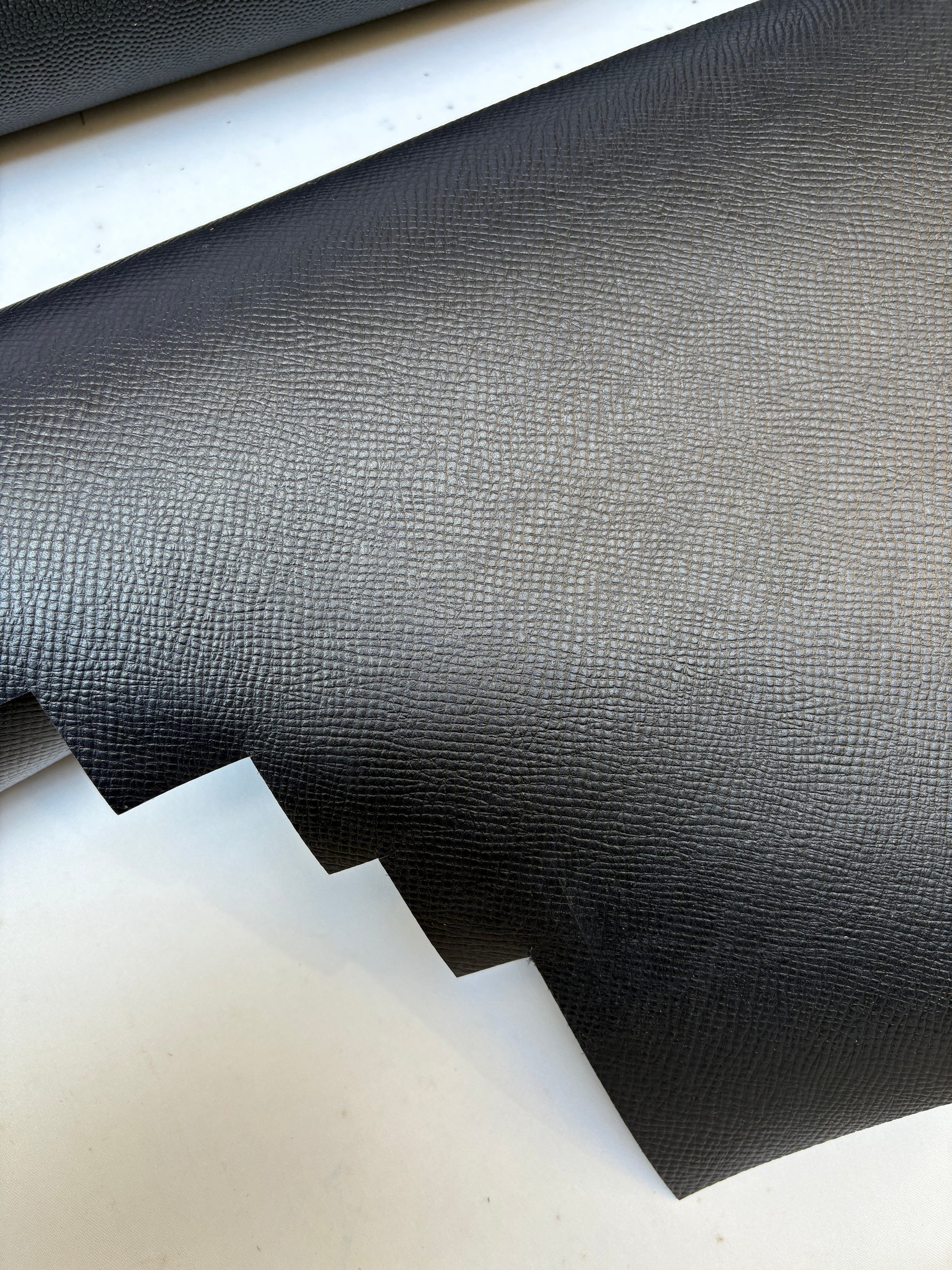 Close-up of black leather, some part had cut