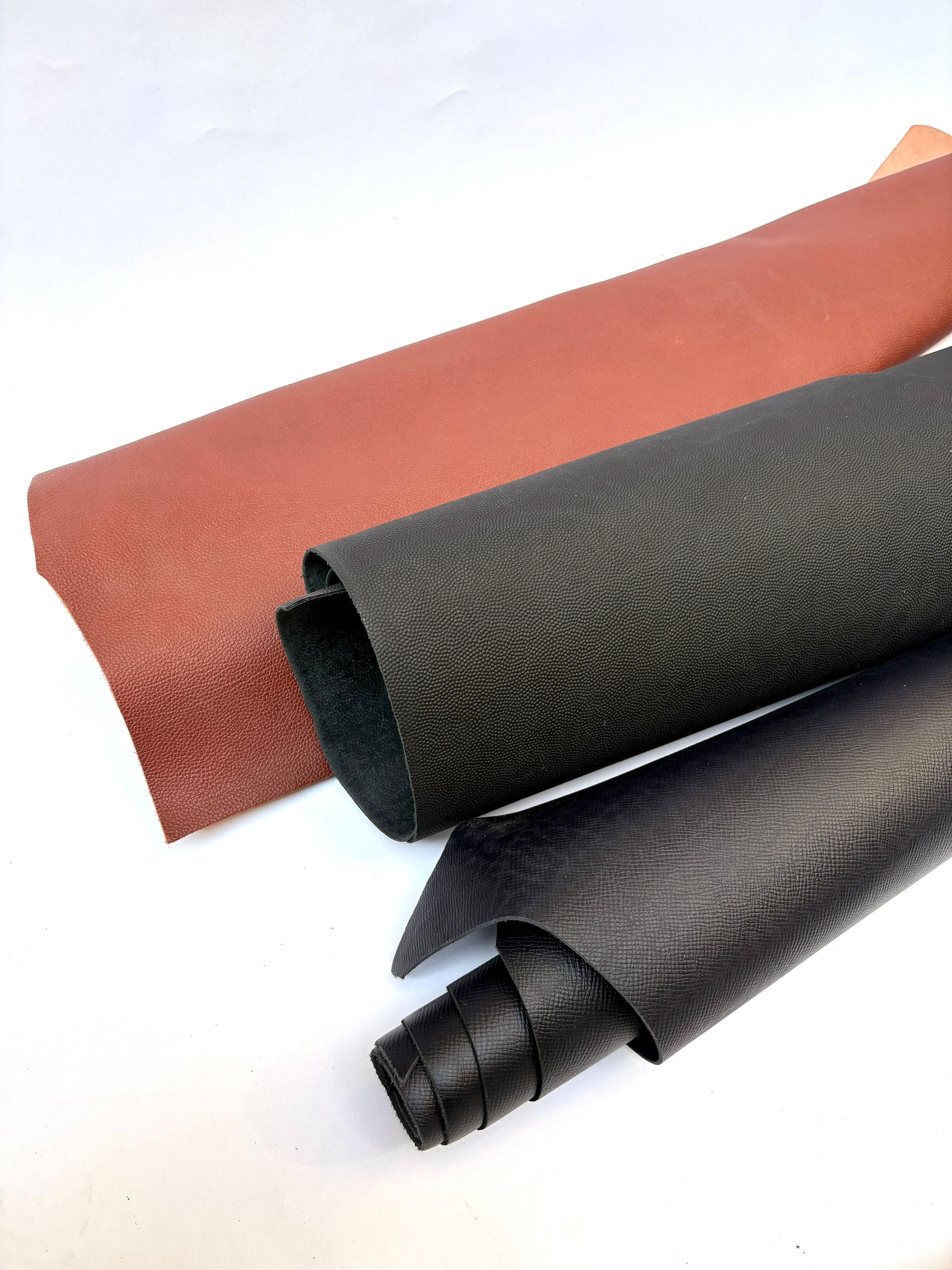Two rolls of brown and black leather 