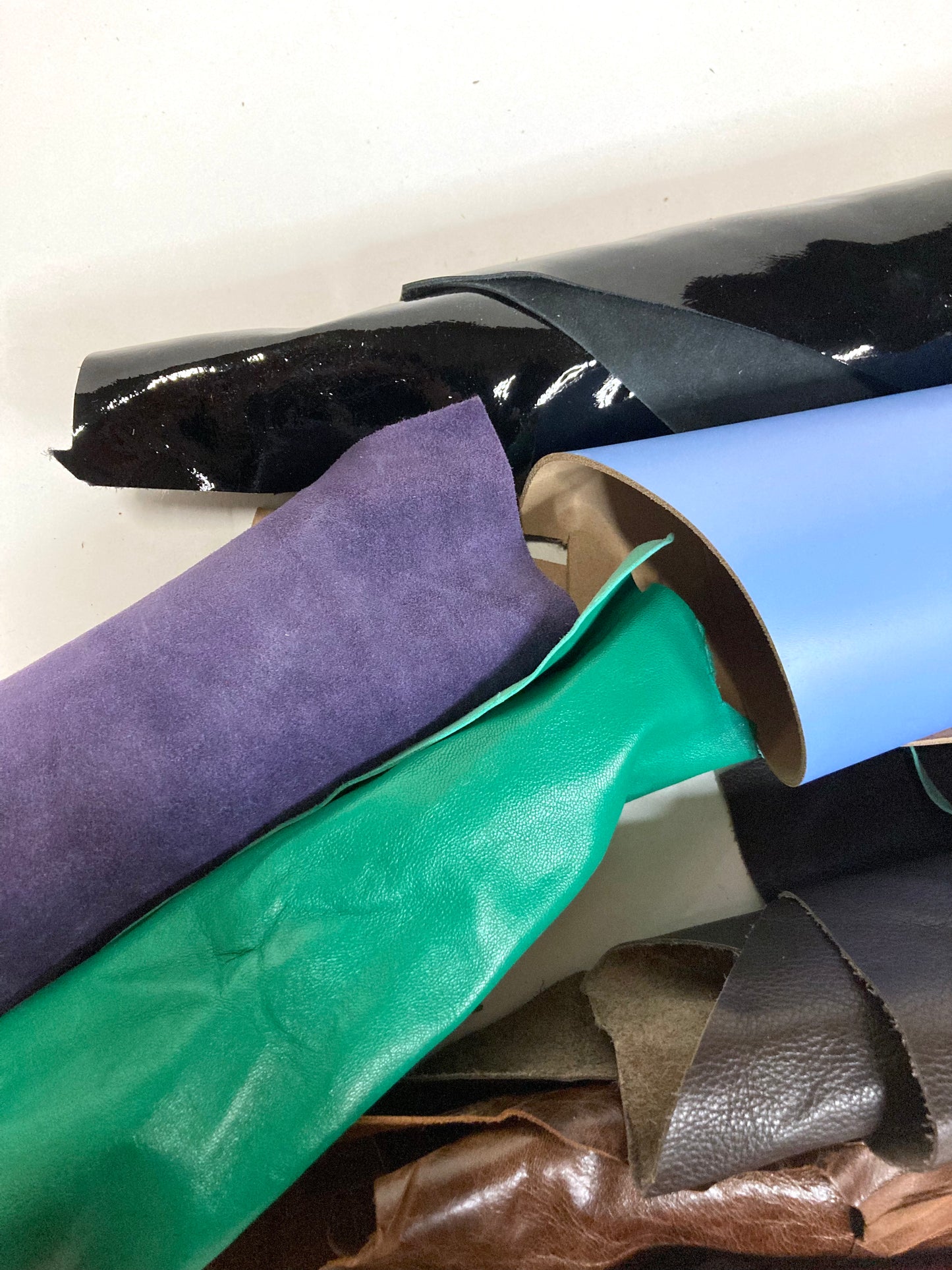 Collection of various coloured leather rolls, some has shiny texture
