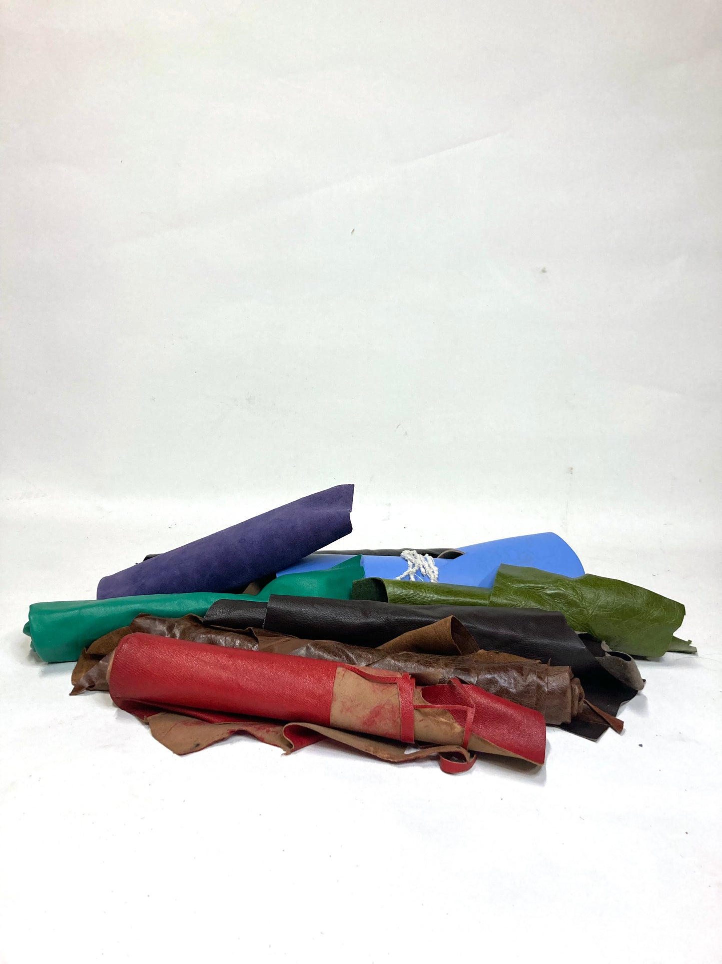 Collection of various coloured leather rolls, some have cut parts
