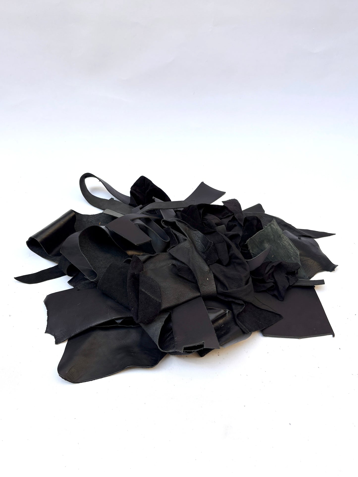Pile of black leather offcuts with various textures 