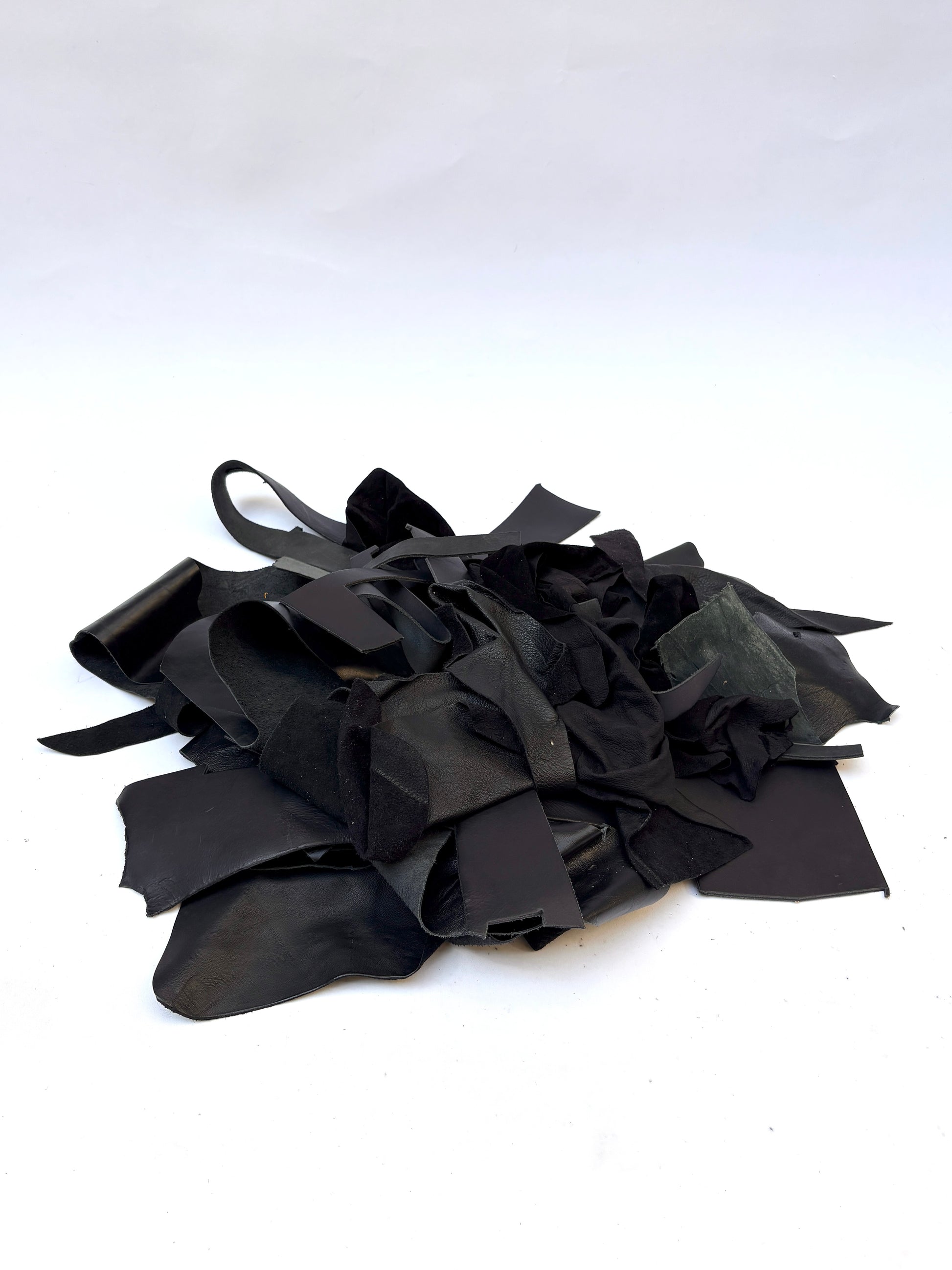 Pile of black leather offcuts with various textures 