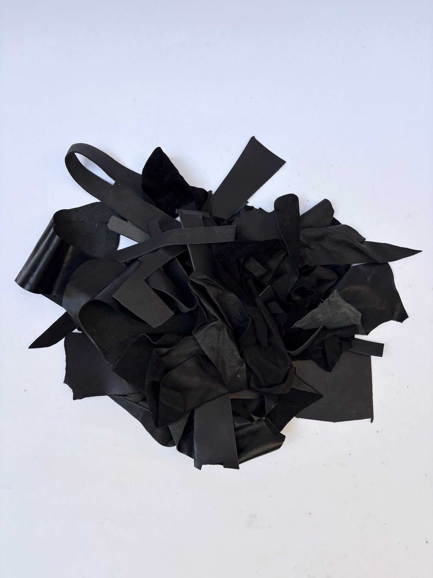 Pile of black leather offcuts with various textures and sizes