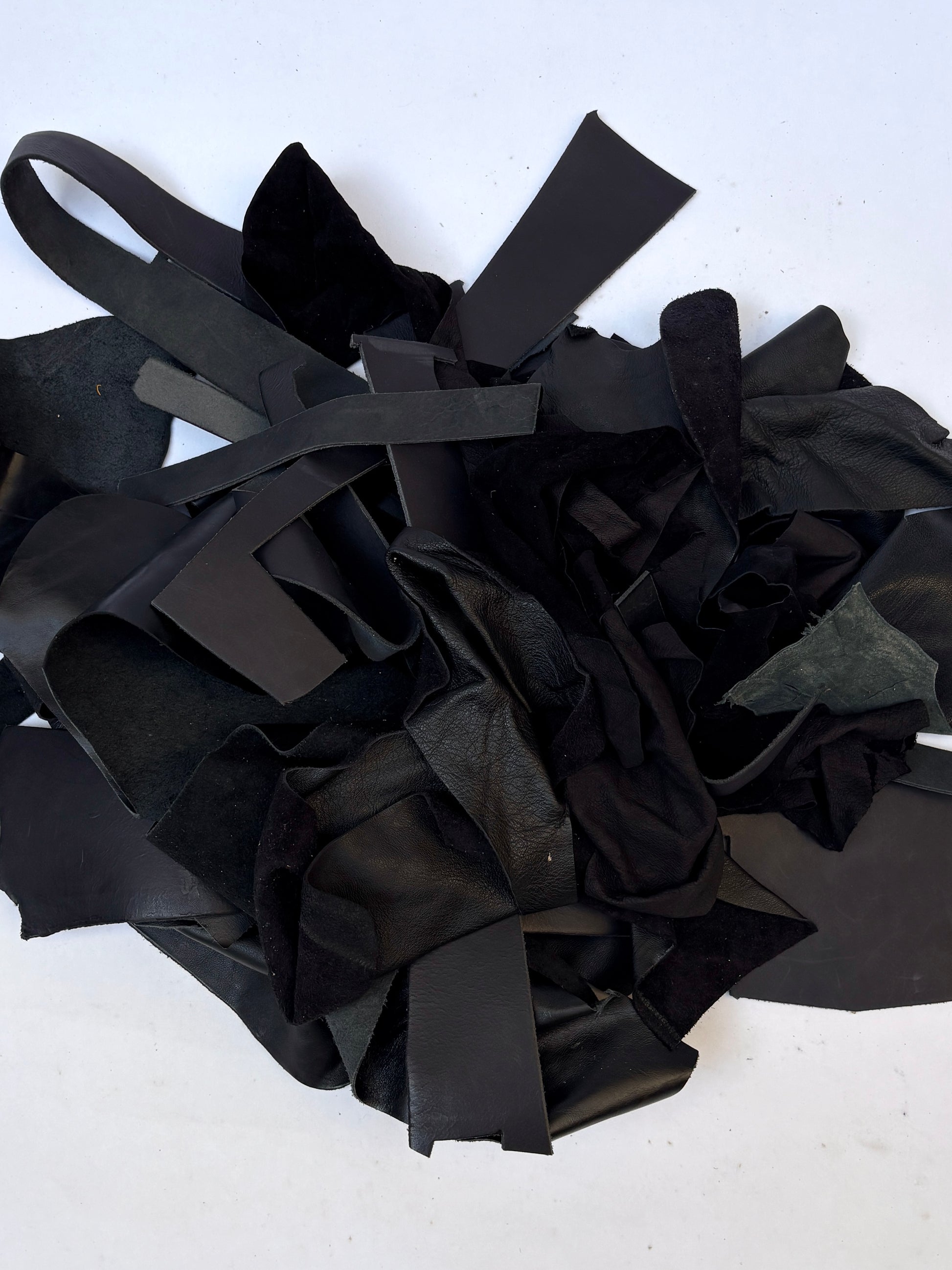 Pile of black leather offcuts with various textures 