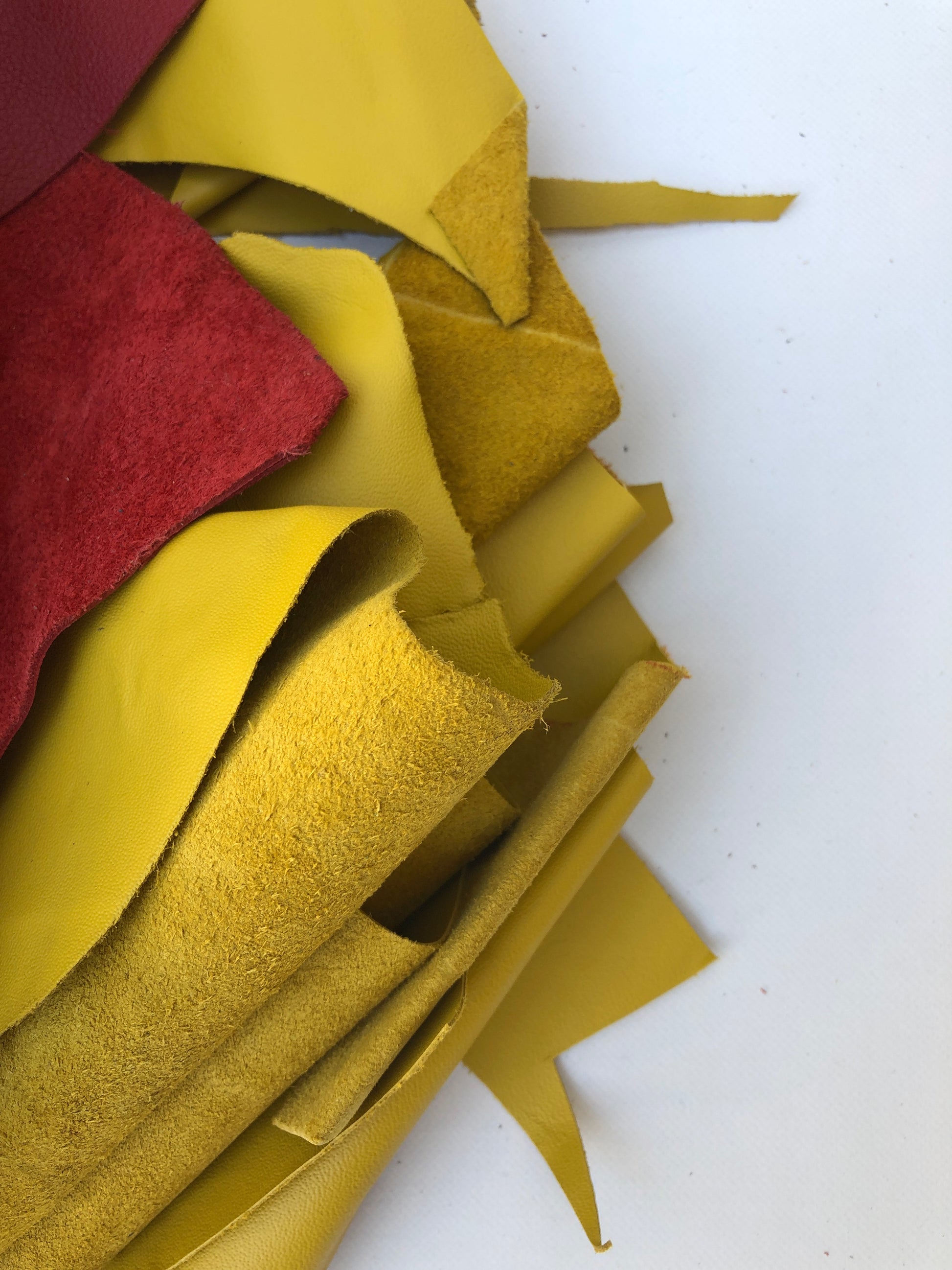 Close-up of offcuts leather with red and yellow, soft texture visible