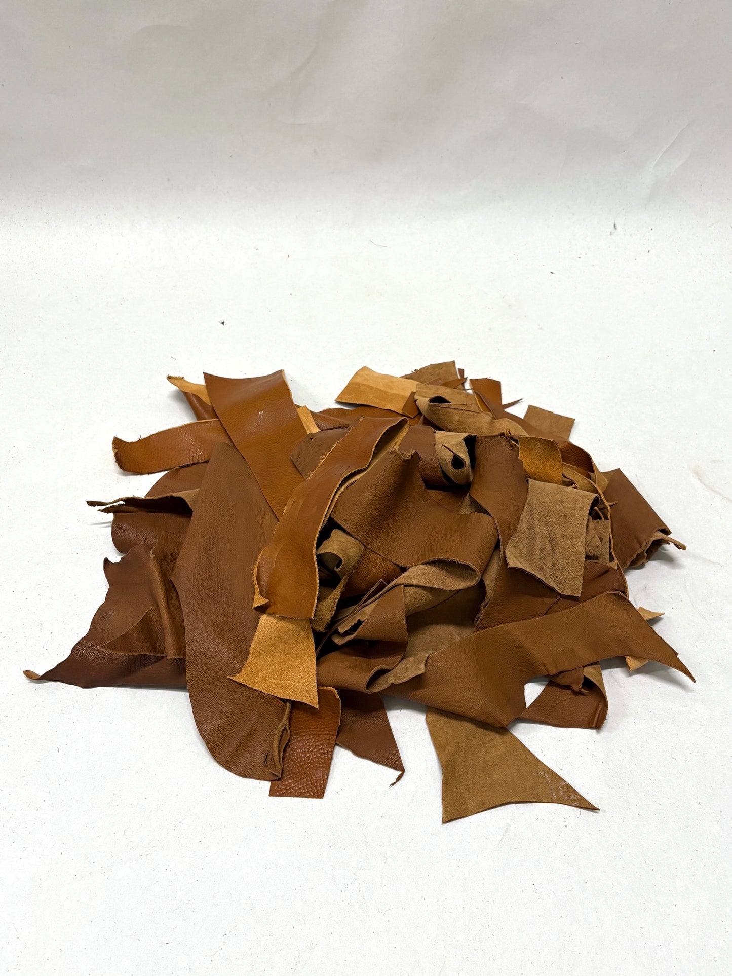 Pile of light brown leather offcuts 