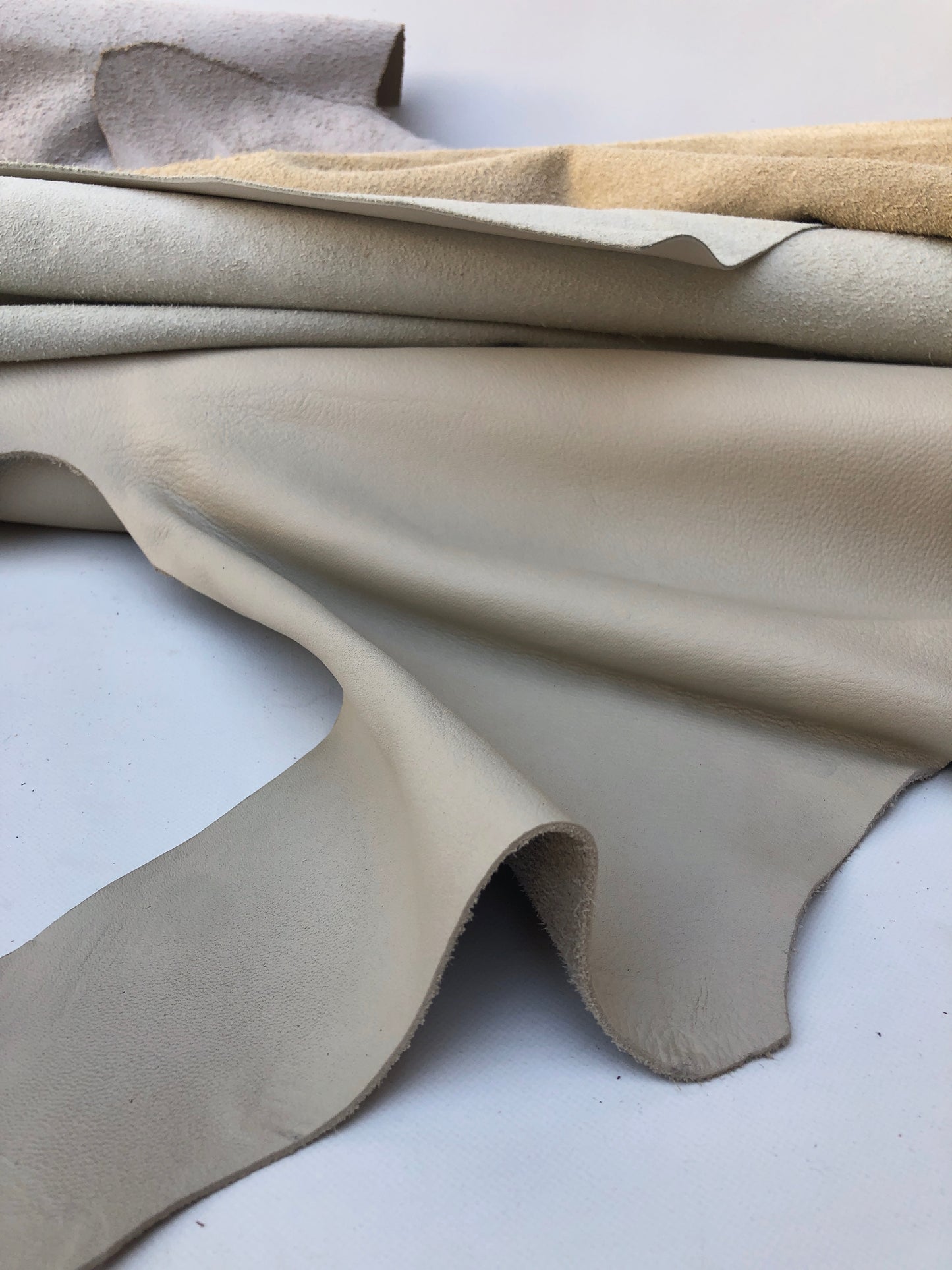 Close-up of cream coloured leather pieces with soft texture, some part had cut