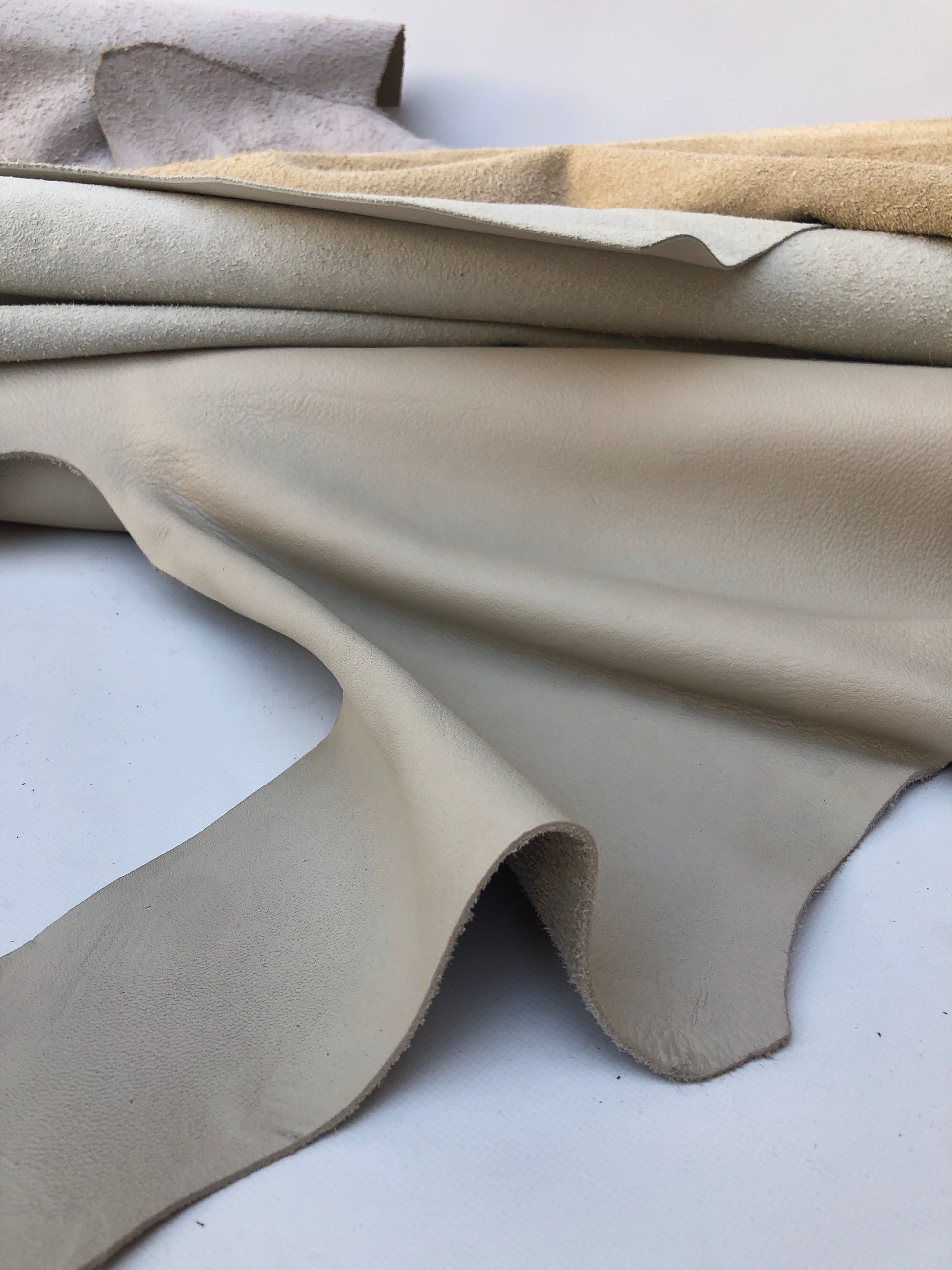 Close-up of cream coloured leather pieces with soft texture, some part had cut
