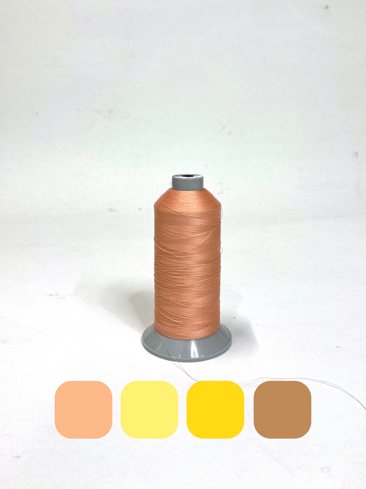 A spool of orange coloured thread with colour swatches below 