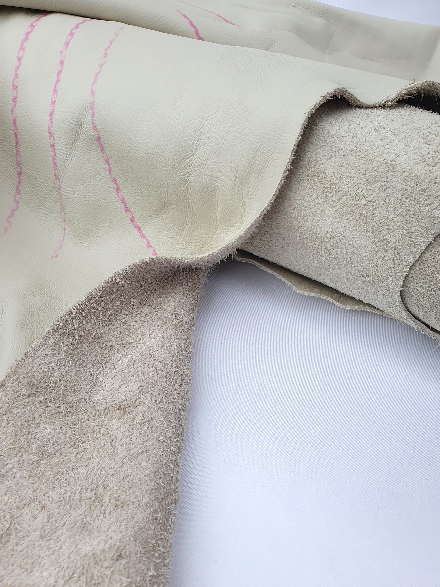 Two cowhide bone white rolled leather with visible marking lines