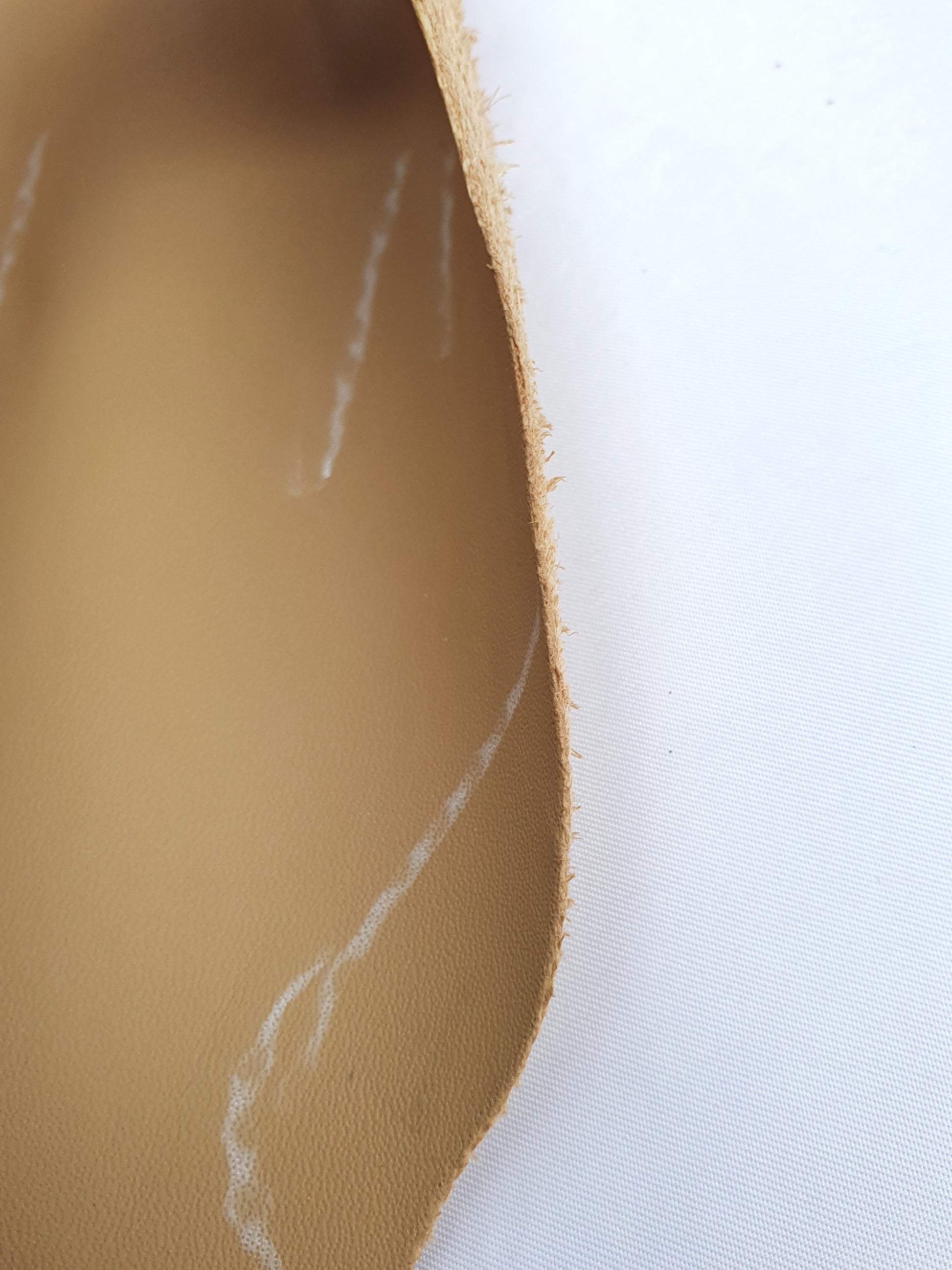 Unfolded cowhide camel rolled leather with visible marking lines 