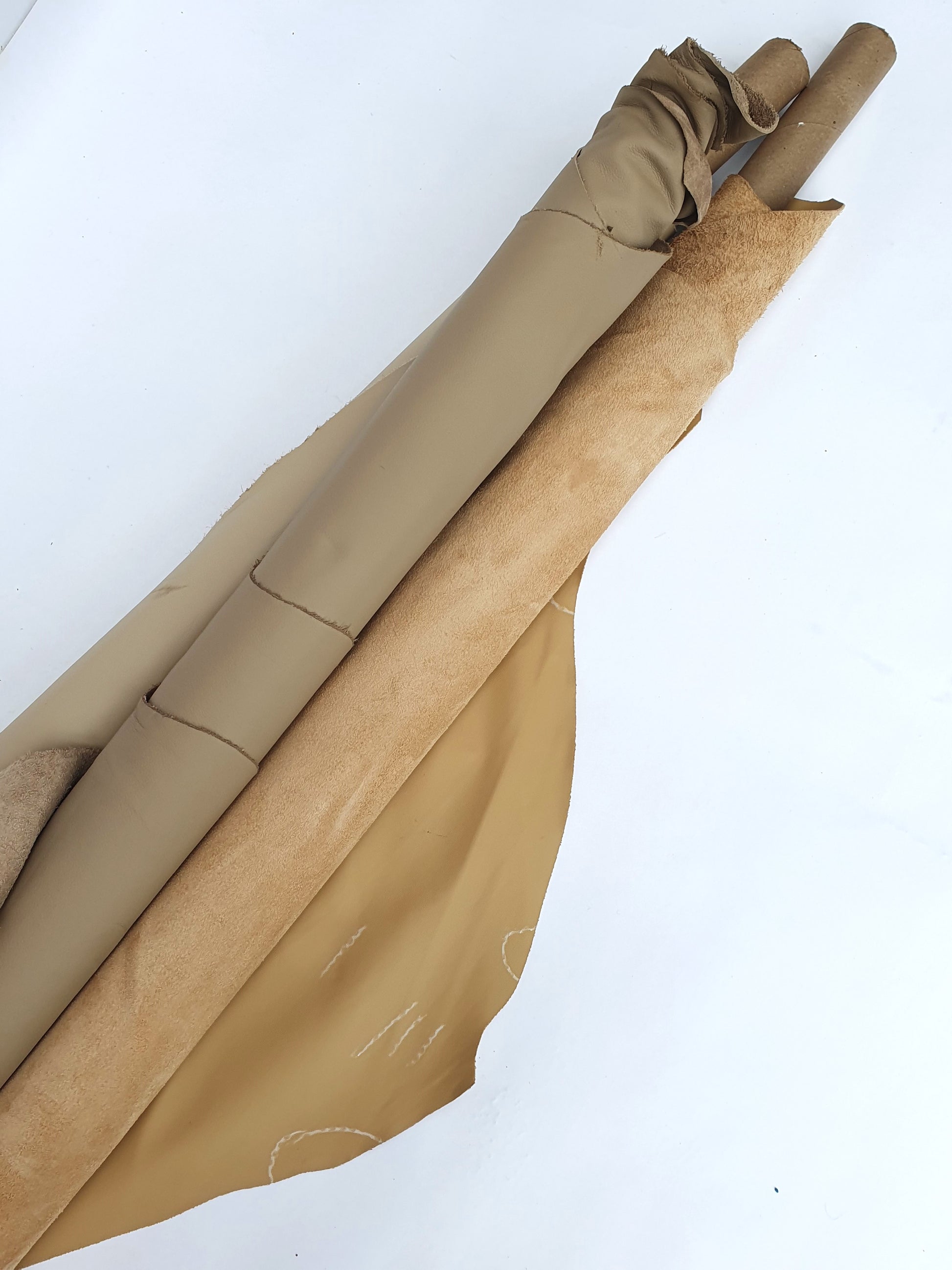 Two cowhide camel rolled leather with visible marking lines 