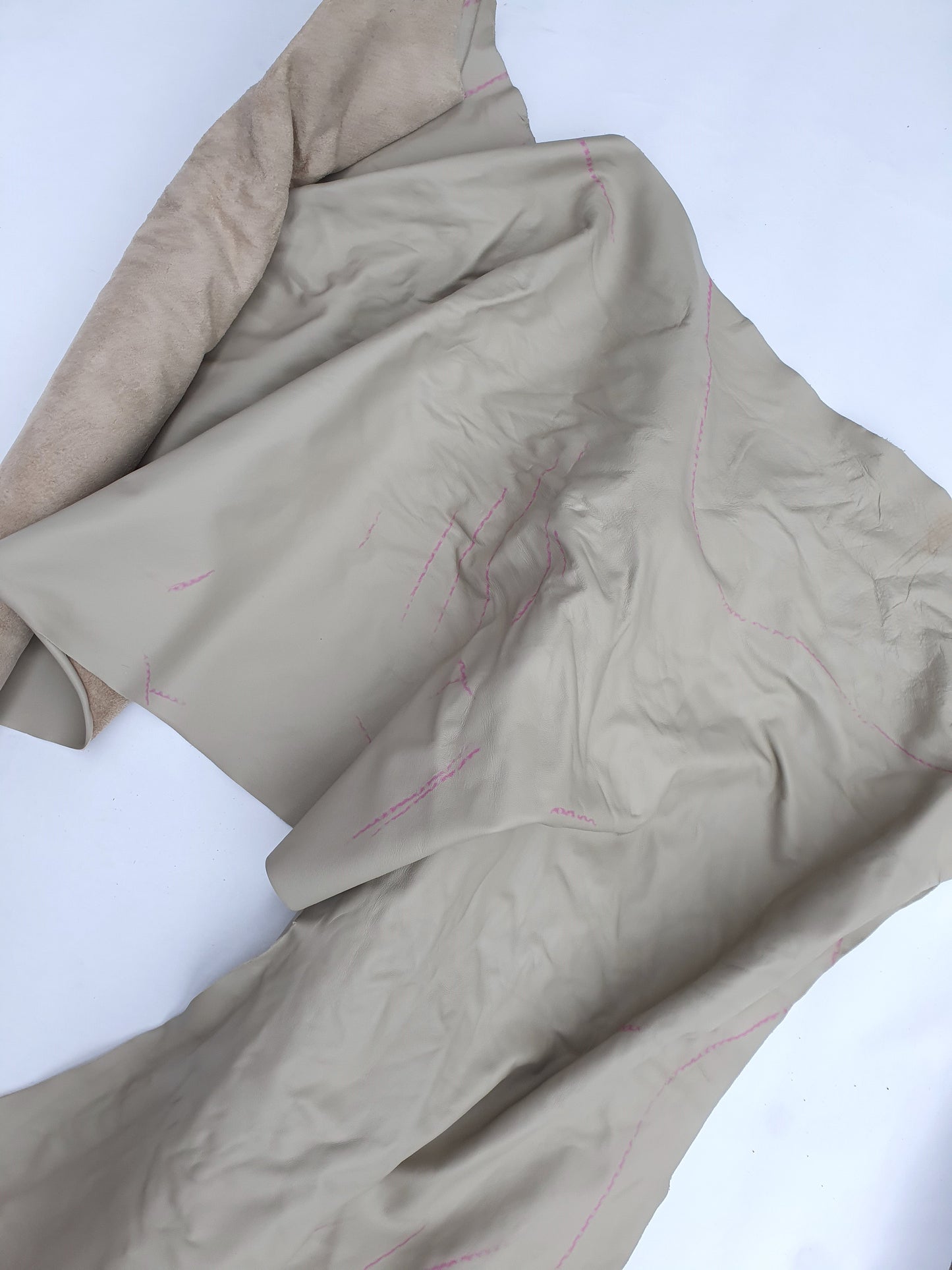 Unfolded beige coloured rolled leather with visible marking lines 