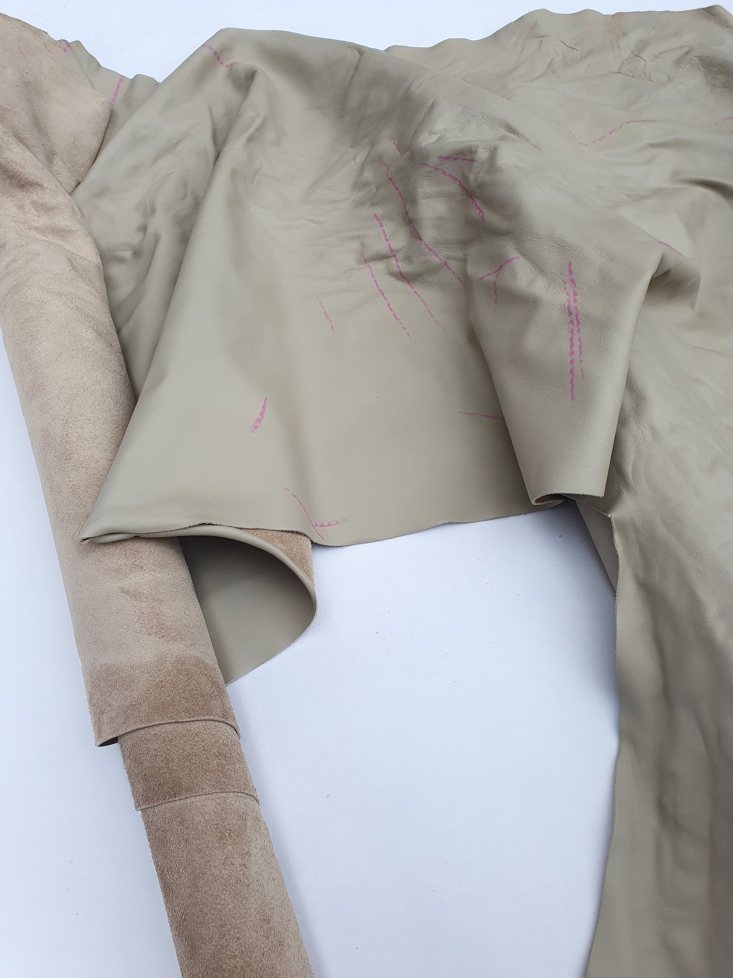 Two beige coloured rolled leather with visible marking lines 