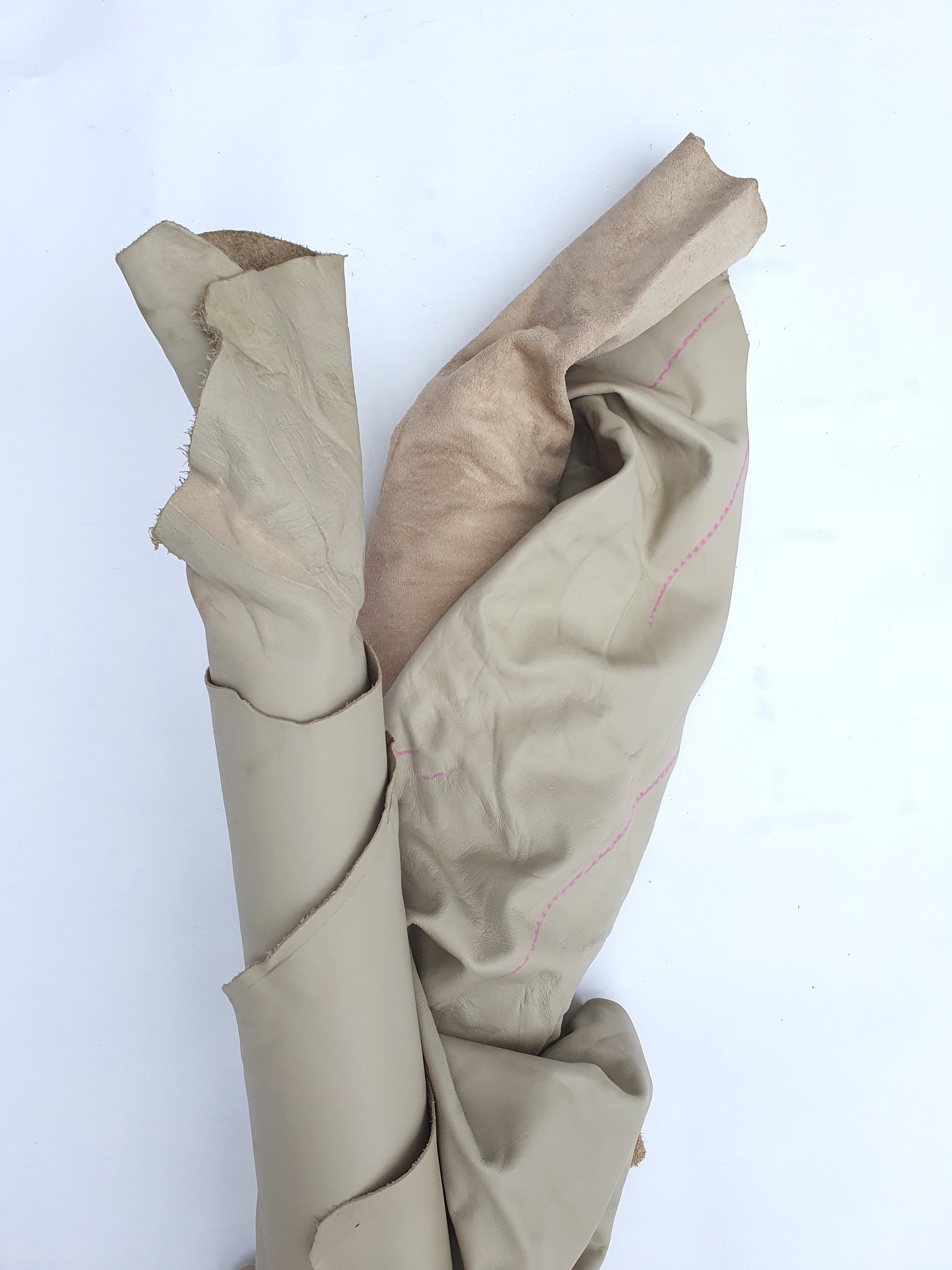 Two beige coloured rolled leather with visible marking lines 