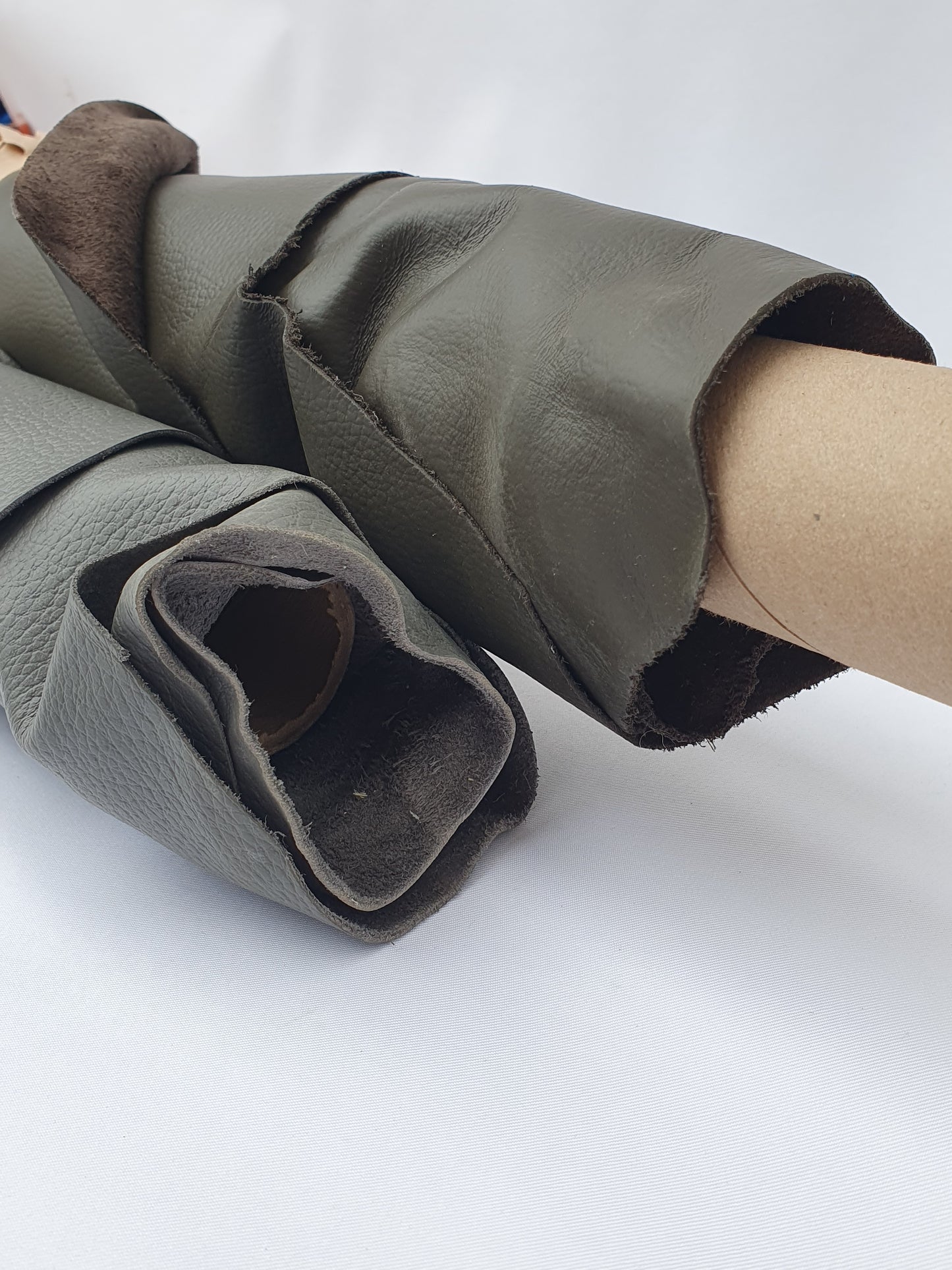 Close-up of rolled dark grey to brown leather showing a soft texture and folded edge